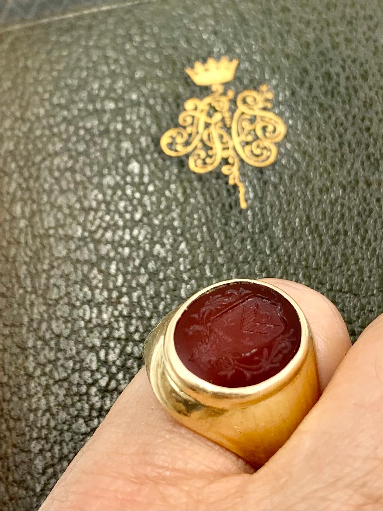 Fine antique Tiffany & Co. 14K gold signet ring with a beautifully engraved carnelian intaglio crest depicting a lion above a shield with two stars, a chevron and a crescent moon. 
The lion symbolizes strength, nobility and power, the crescent moon