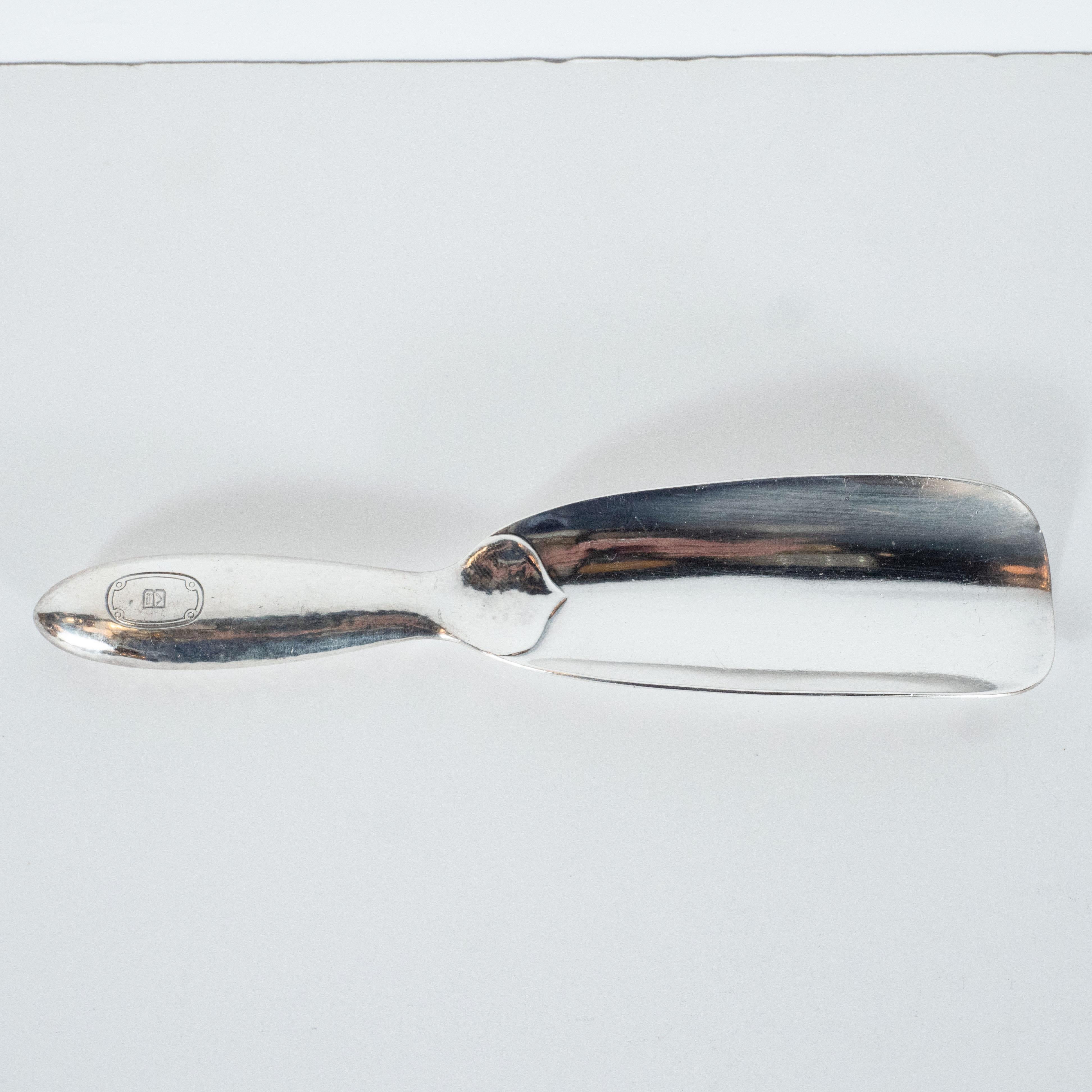 This elegant shoe horn was realized in the United States by Tiffany & Co.- one of America's most illustrious and storied makers of jewelry and sterling silver products, circa 1900. It features a concave body with hand hammered handle with a subtle