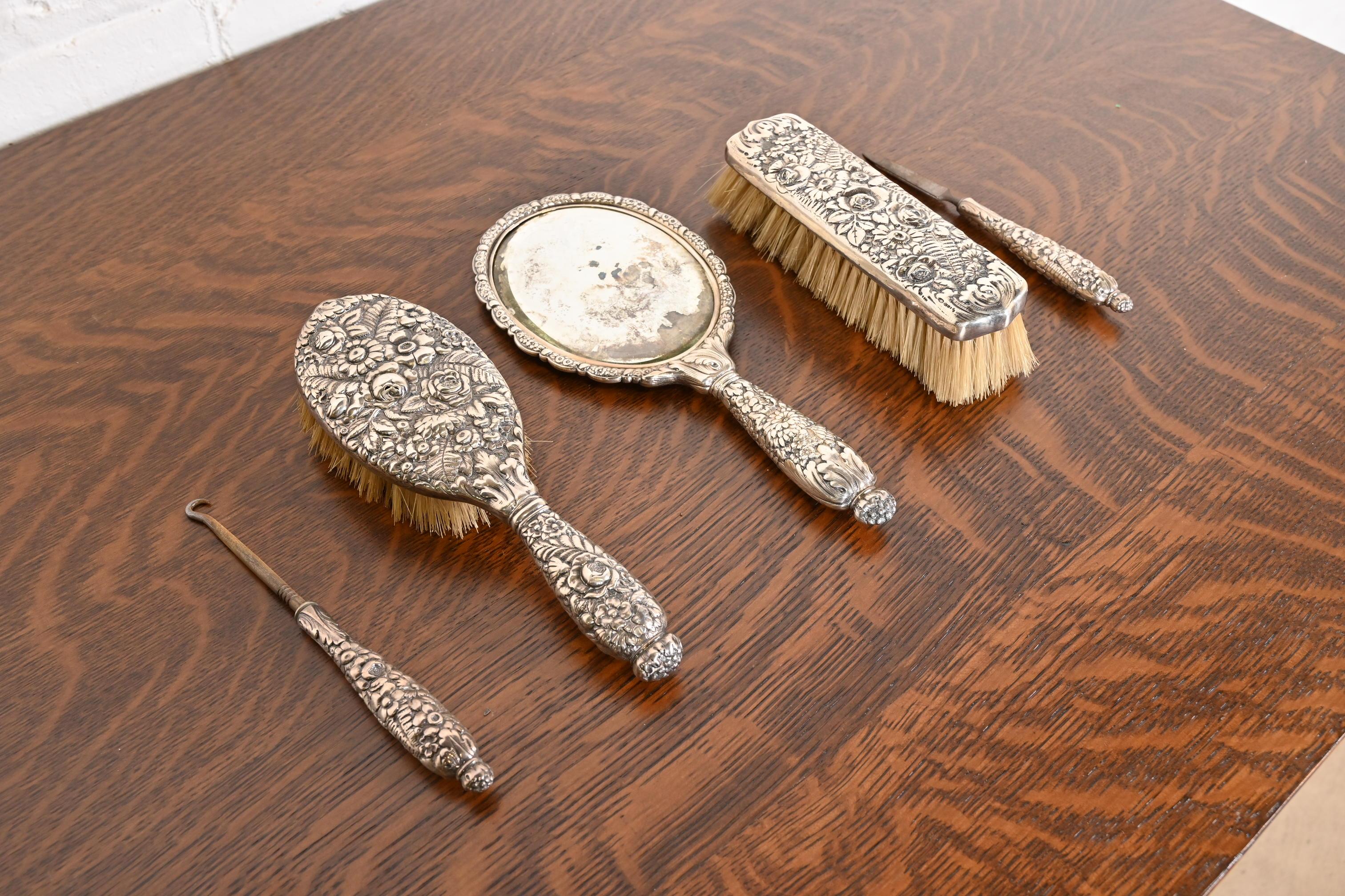 A rare and exceptional antique Art Nouveau sterling silver five-piece dresser set, including: two brushes, hand mirror, nail file, and hair pick

By Tiffany & Co. 

USA, Early 20th Century

Measures: 
Mirror: 11