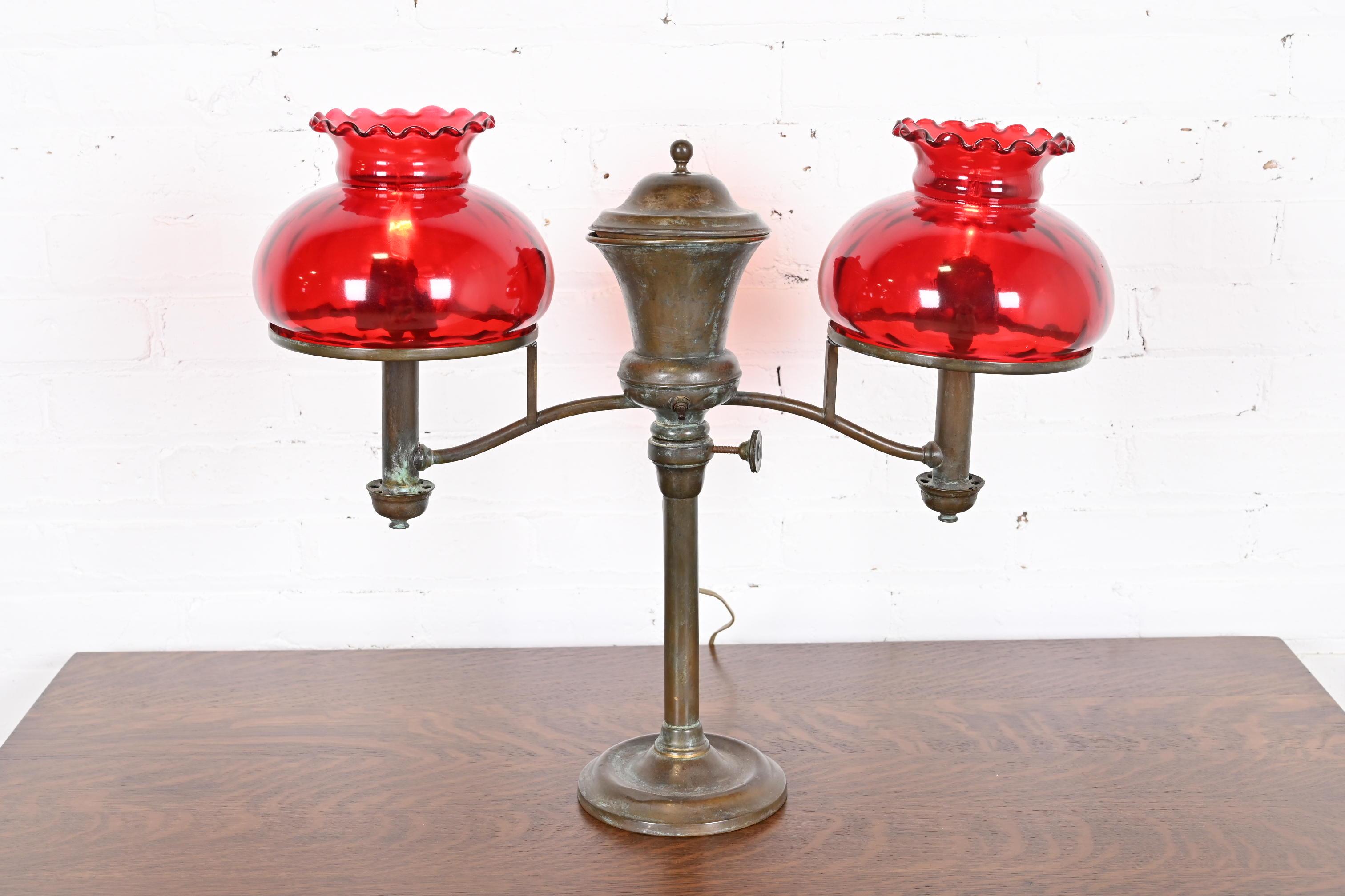 An outstanding Arts & Crafts or Art Deco period double arm student desk lamp

By Hinrichs of New York and retailed by Tiffany & Co.

New York, USA, Late 19th Century

Bronze, with beautiful red art glass shades.

Measures: 23