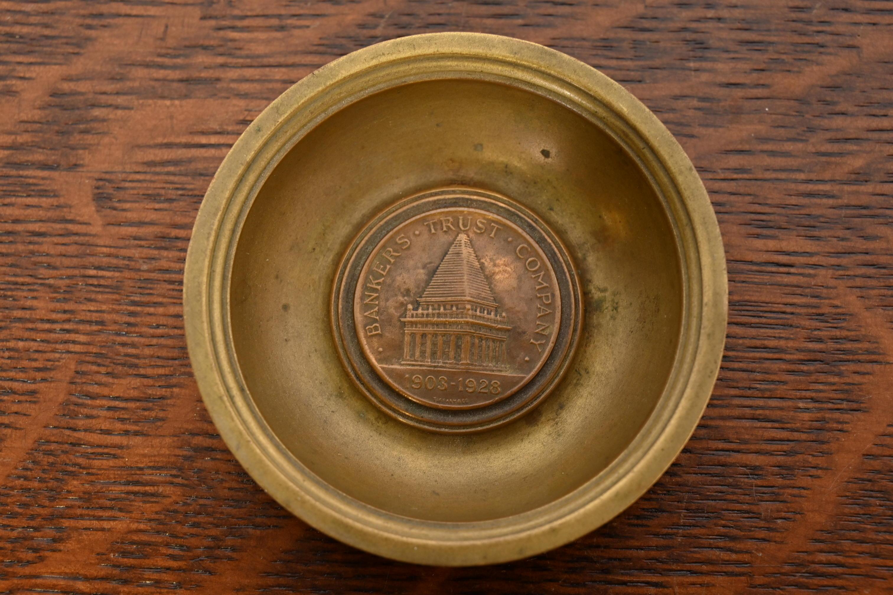 Excepcional cuenco, cenicero o recogedor de bronce antiguo con el emblema de Bankers Trust Company

Por Tiffany & Co. (firmado en la parte inferior)

EE.UU., circa 1920s

Medidas: 3