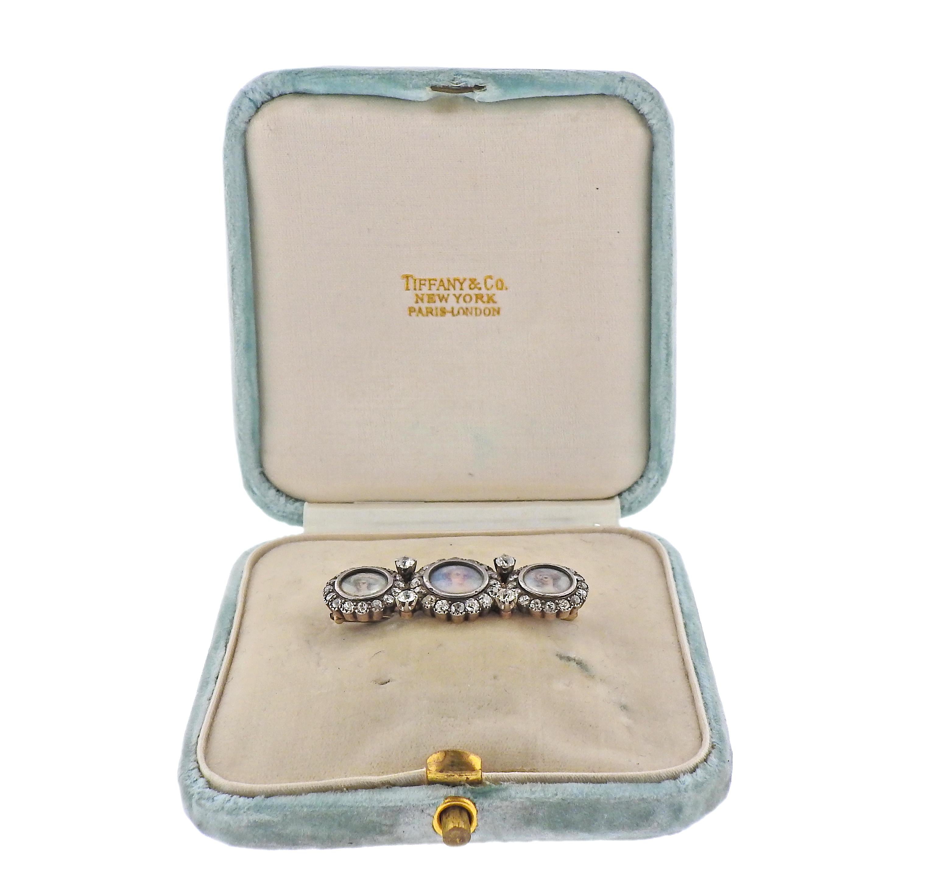 Antique Tiffany & Co 14k gold and silver top brooch, featuring three miniature hand painted portrait of ladies, surrounded with approx. 2.10ctw in old mine cut diamonds. Comes in original T & Co box. Brooch measures 42mm x 15mm. Marked: Tiffany &