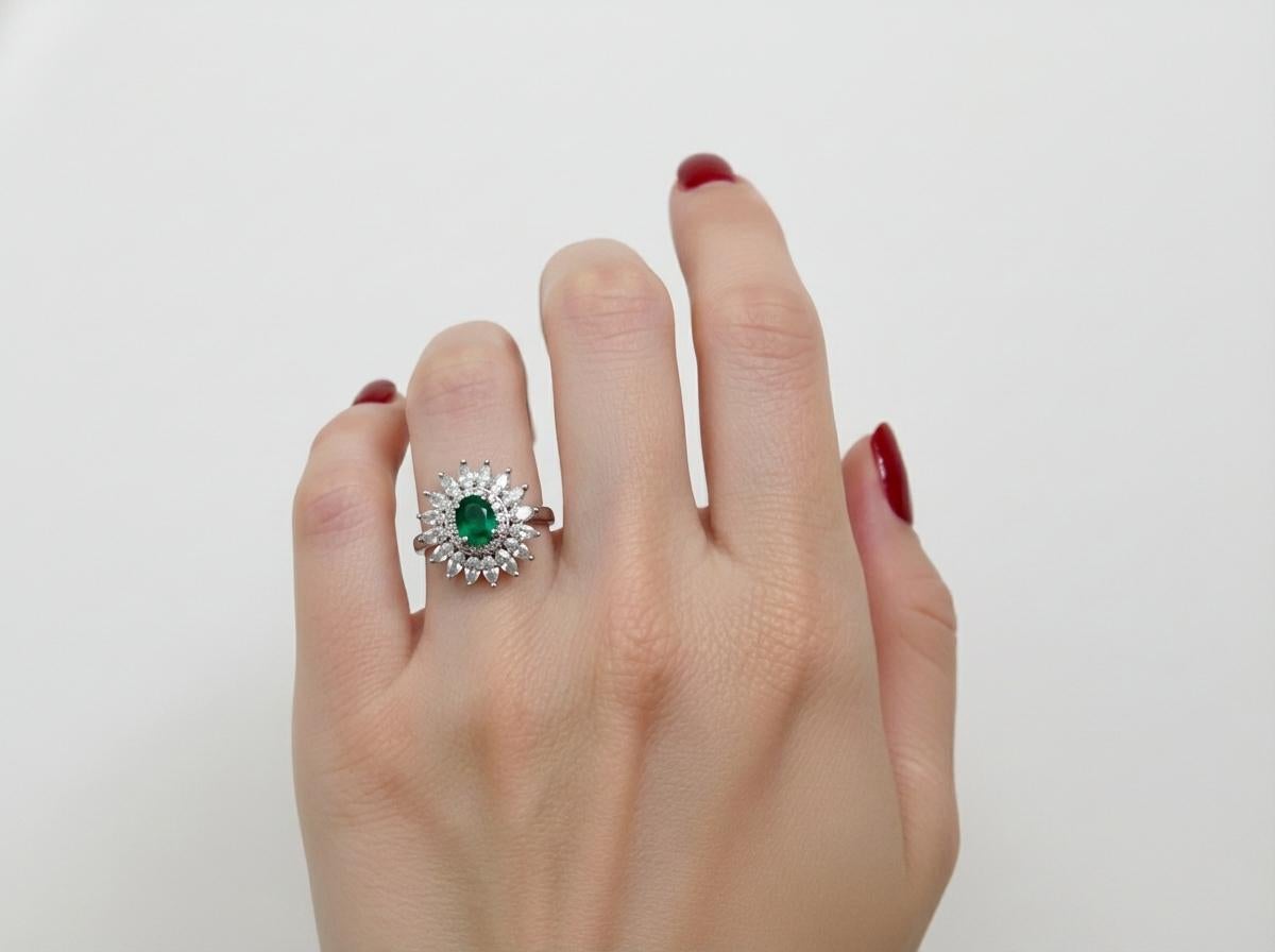 Questo eccezionale anello antico di Tiffany & Co. mette in mostra uno straordinario smeraldo naturale incastonato al centro di un elegante design a grappolo in platino. Il vibrante smeraldo verde è accentuato da un'aureola di diamanti splendidamente