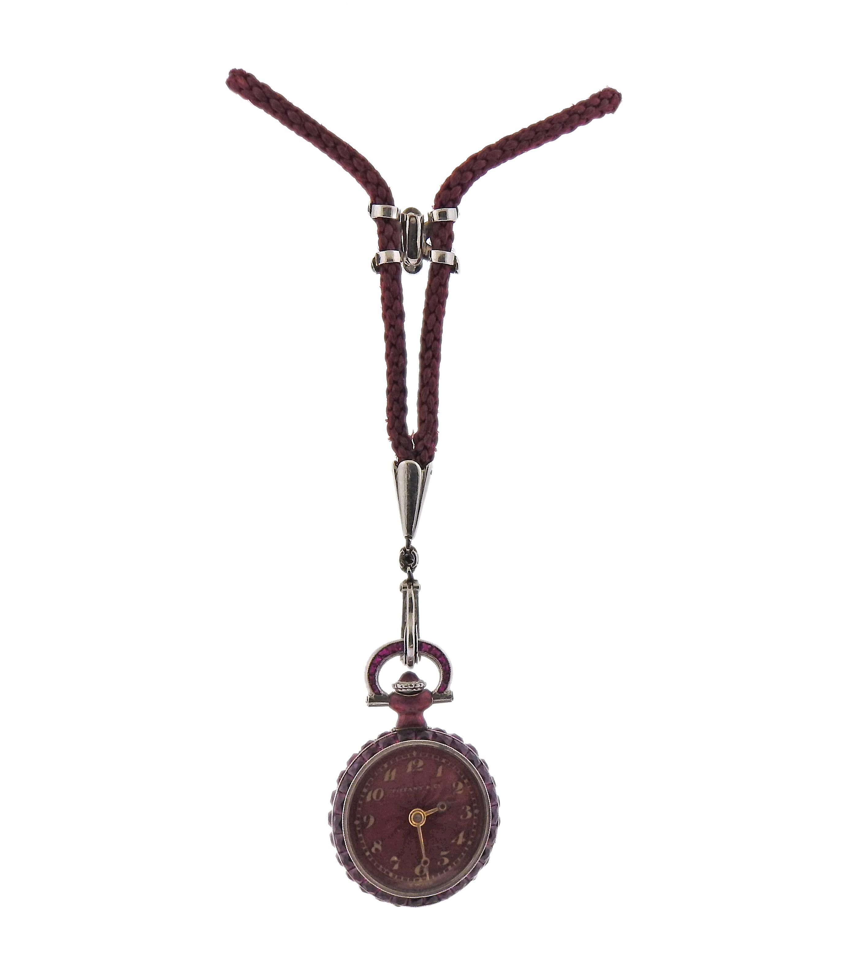 Antique platinum Tiffany & Co pocket watch, suspended on a cord necklace. Case adorned with rubies and diamonds. Case measures 18mm in diamonds. 28