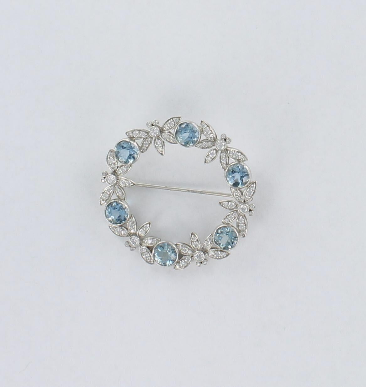 This is an extraordinary platinum aquamarine and diamond by Tiffany & Co.  Icy cool blue round bezel-set aquas alternate with diamonds designed as dragonflies to create this radiant piece.  This fabulous pin is 1 1/2 inch wide and is in its original