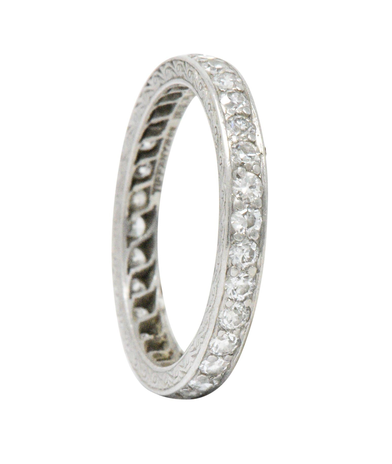 Band entirely set with 32 round Swiss cut diamonds weighing approximately 0.64 CTW, G color and VS to I clarity

Detailed hand engraved scrolled design on both sides of the ring, one side including hand engraved initials with date

Fully signed
