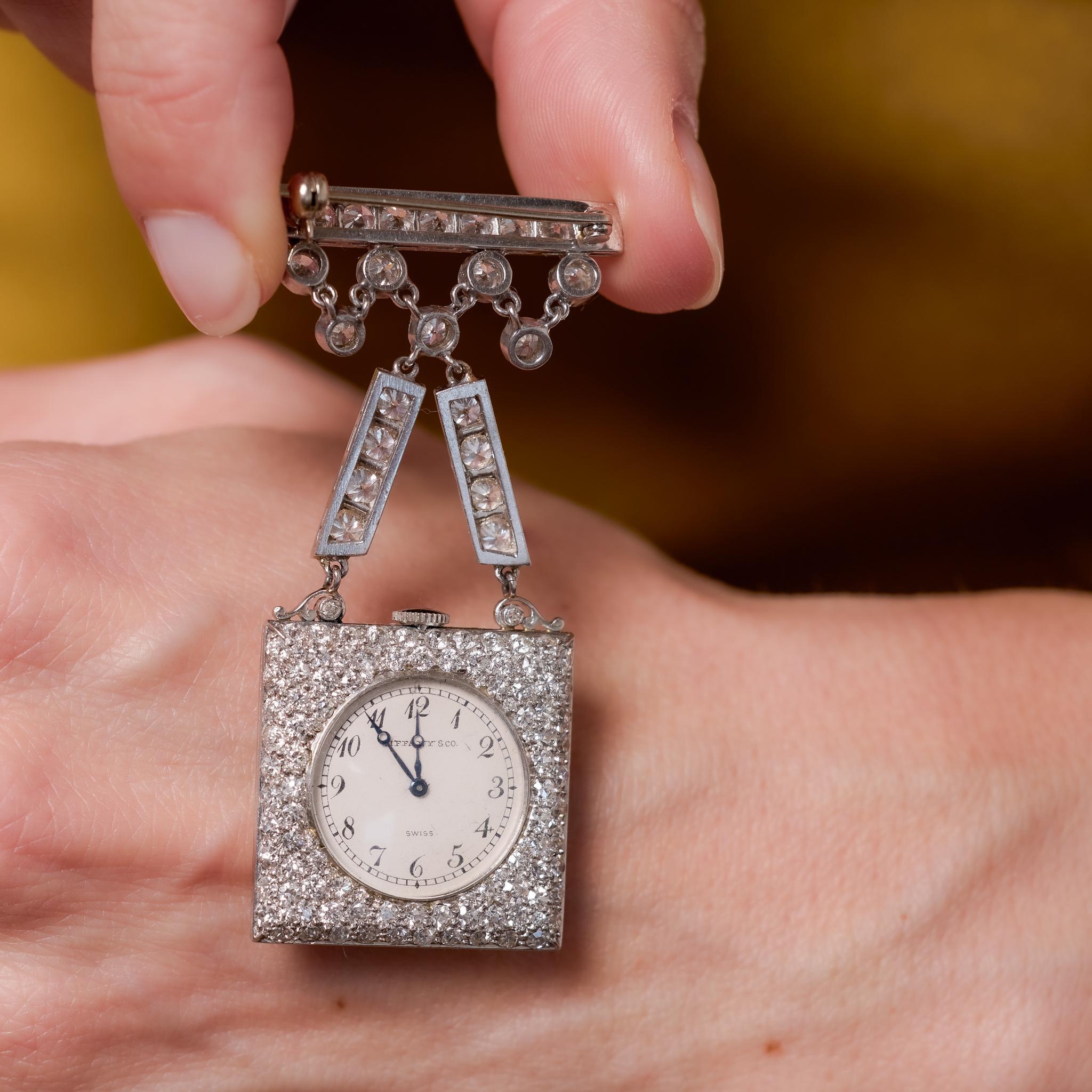 Crafted in the 1930s, this exceptional Art Deco watch brooch by Tiffany & Co. features 339 old European and single cut diamonds totaling approximately 13.40 carats, graded G color and VS clarity. The brooch is elegantly constructed in platinum with