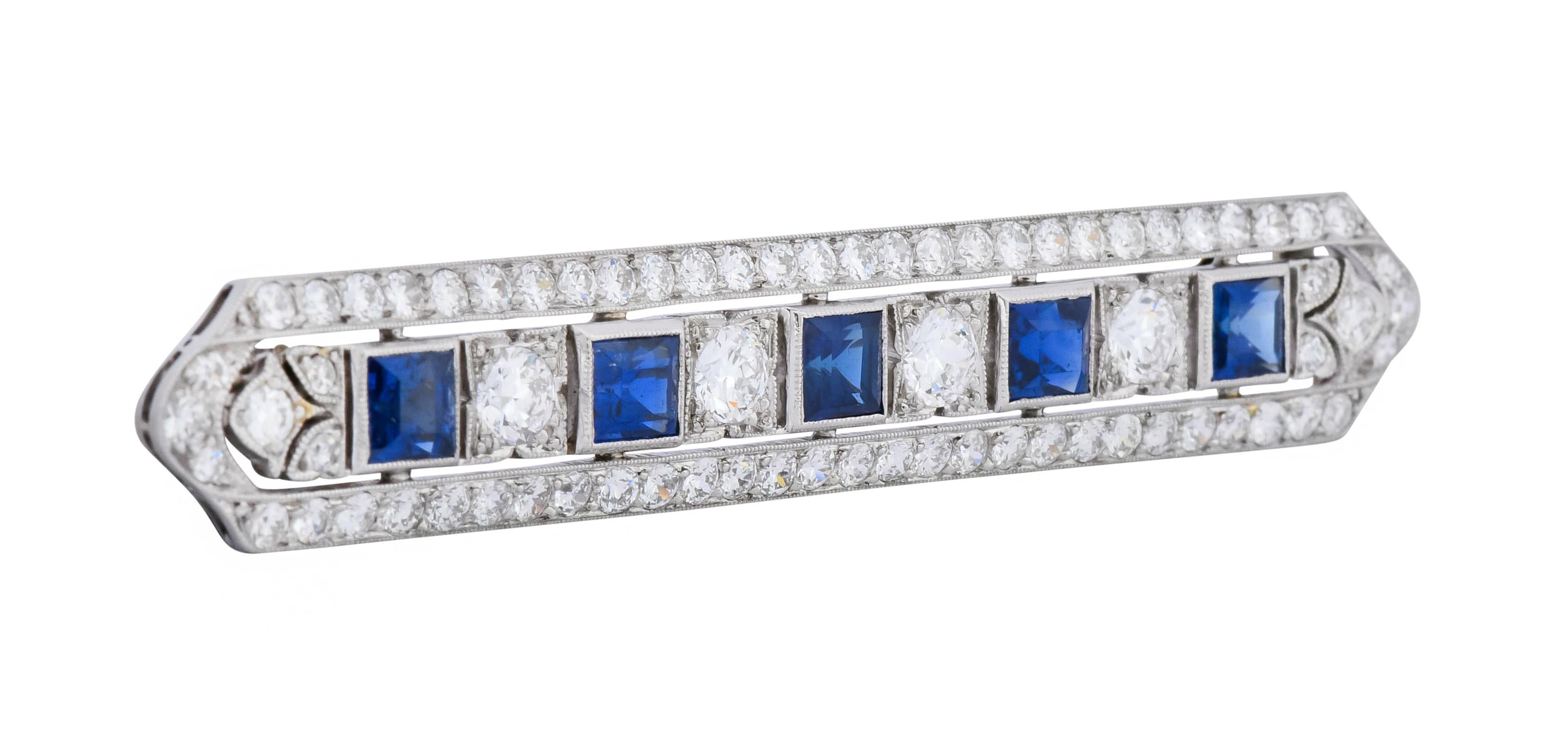 Bar style brooch centering five square cut sapphire weighing approximately 2.00 carats total, very well-matched and bright blue in color

Bezel set East to West in an elongated millegrain frame bead set throughout by round brilliant and single cut