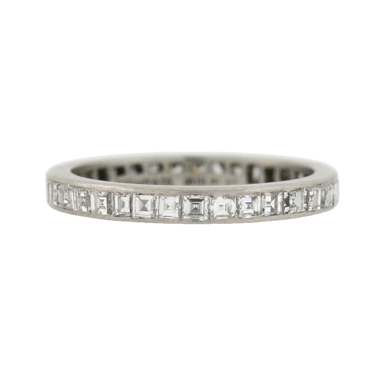 This gorgeous diamond eternity band is a signed Tiffany & Co. ring from the Art Deco (ca1920) era! Made of platinum, the ring features a row of beautiful Carré Cut diamonds, which carry all the way around the outer surface in a continuous channel