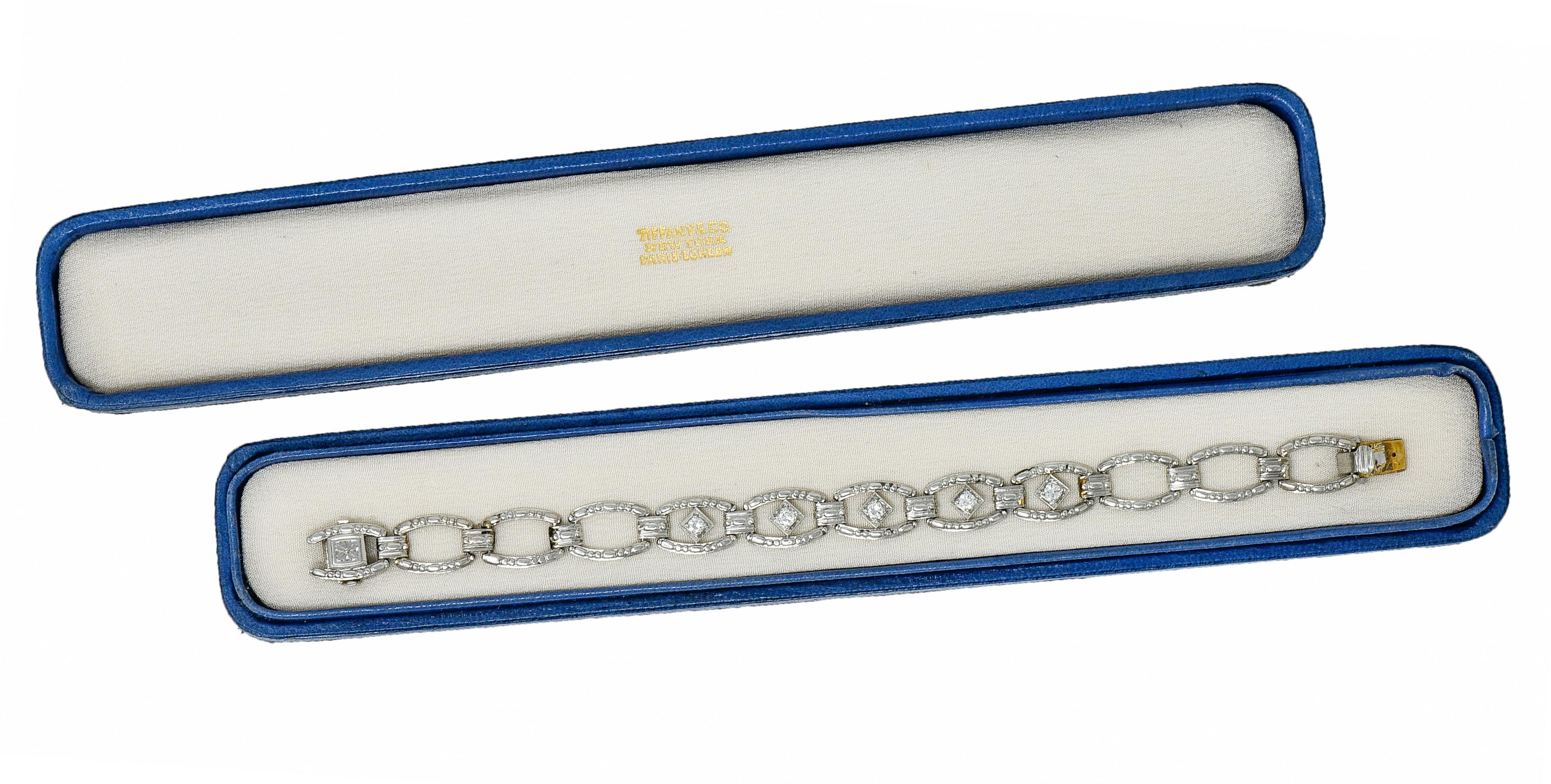 Link style bracelet with elongated rectangular cushion links alternating with spacer links

Featuring a dot and dash motif throughout and a deeply engraved orange blossom at clasp

Links center five navette forms set with transitional cut diamonds