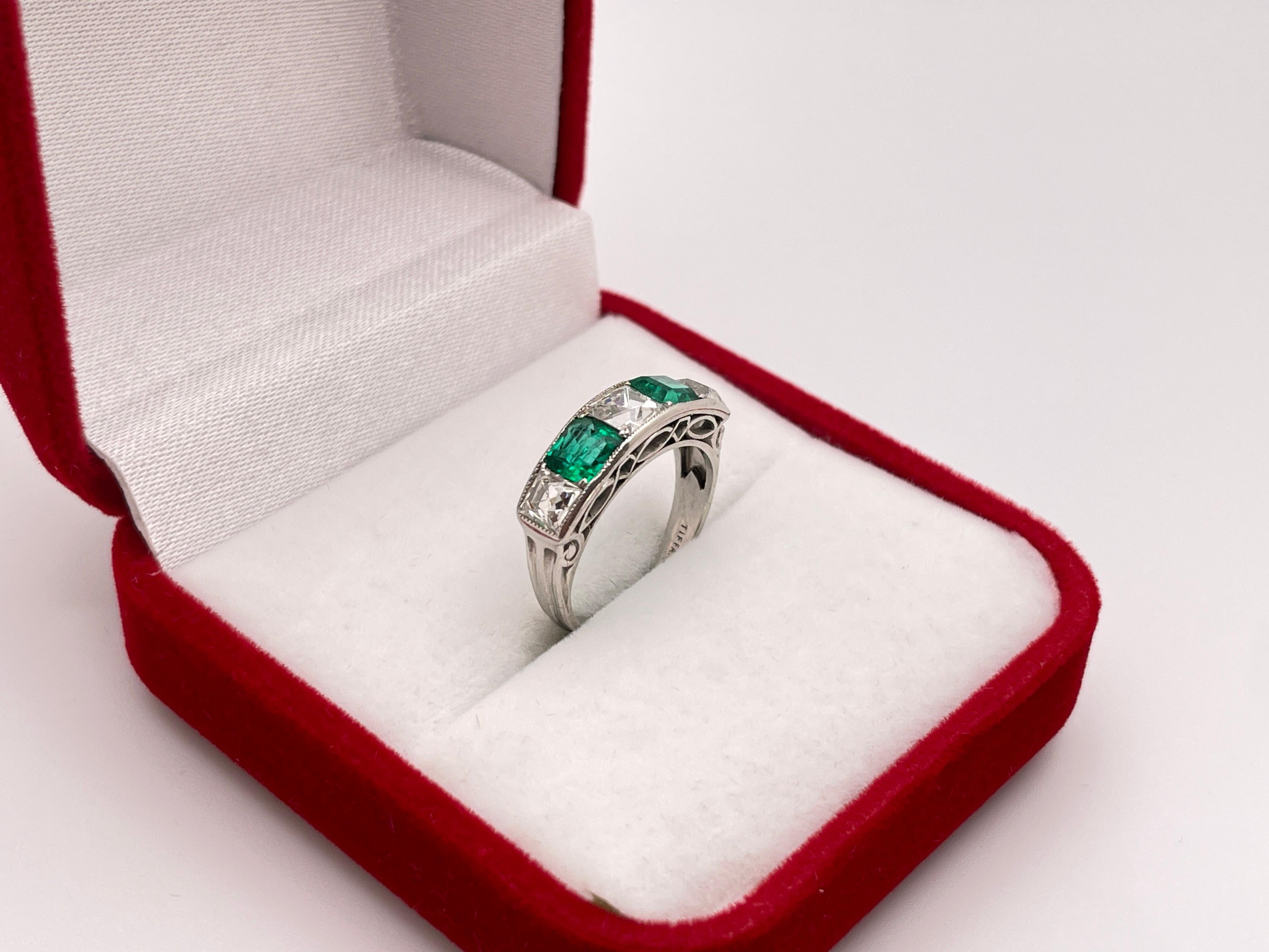 An extraordinary Artdeco Tiffany & Co. emerald and diamond platinum ring / wedding band. Mounted with three original French cut diamonds weighing a total of approximately 1.75 CT, G-H color, VS1 clarity. Separated by two natural square cut emeralds