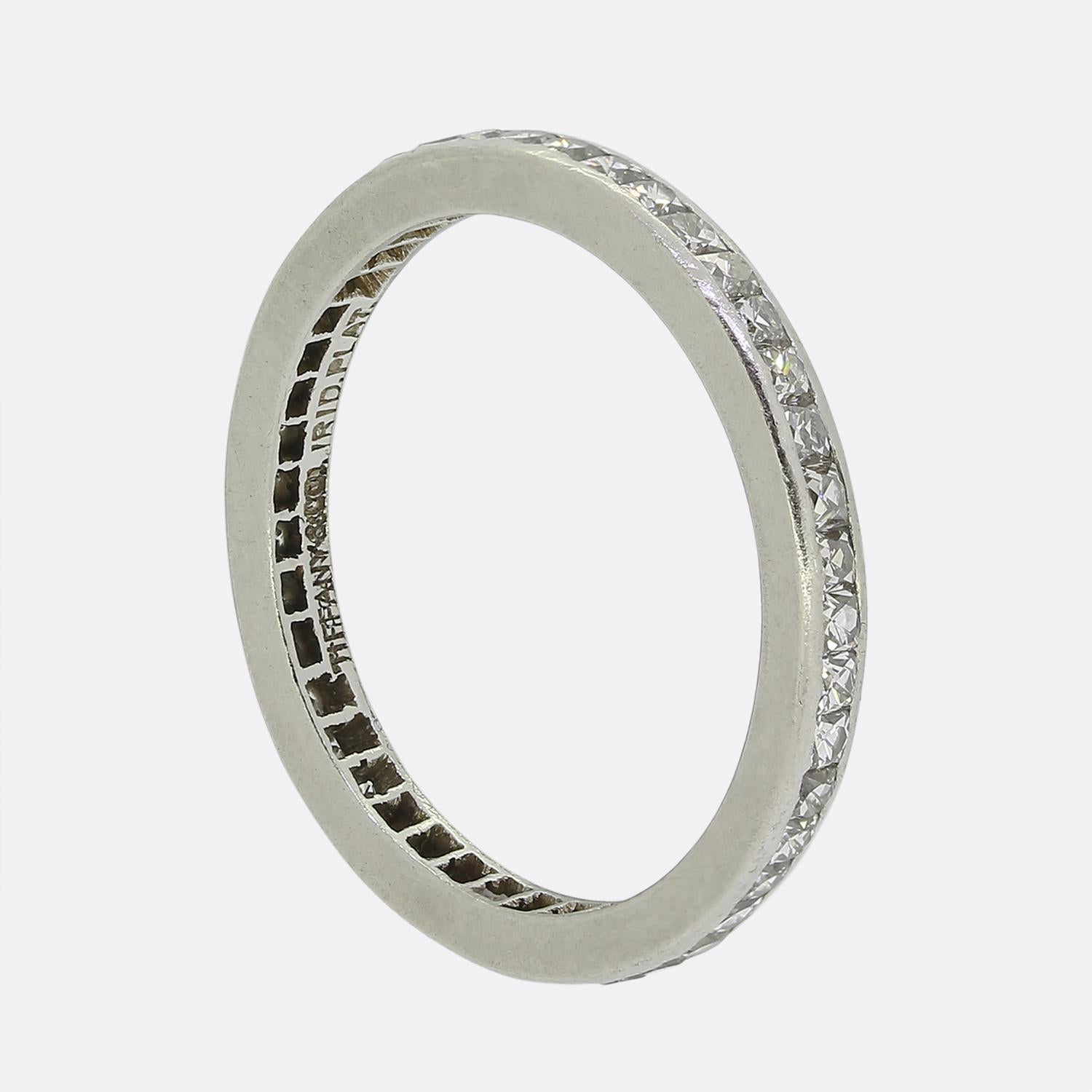 Here we a classically styled diamond eternity ring from the world renowned jewellery designer, Tiffany & Co. This Art Deco platinum piece features 43 French cut diamonds; all of which have been bezel set in a single line formation to wrap around the