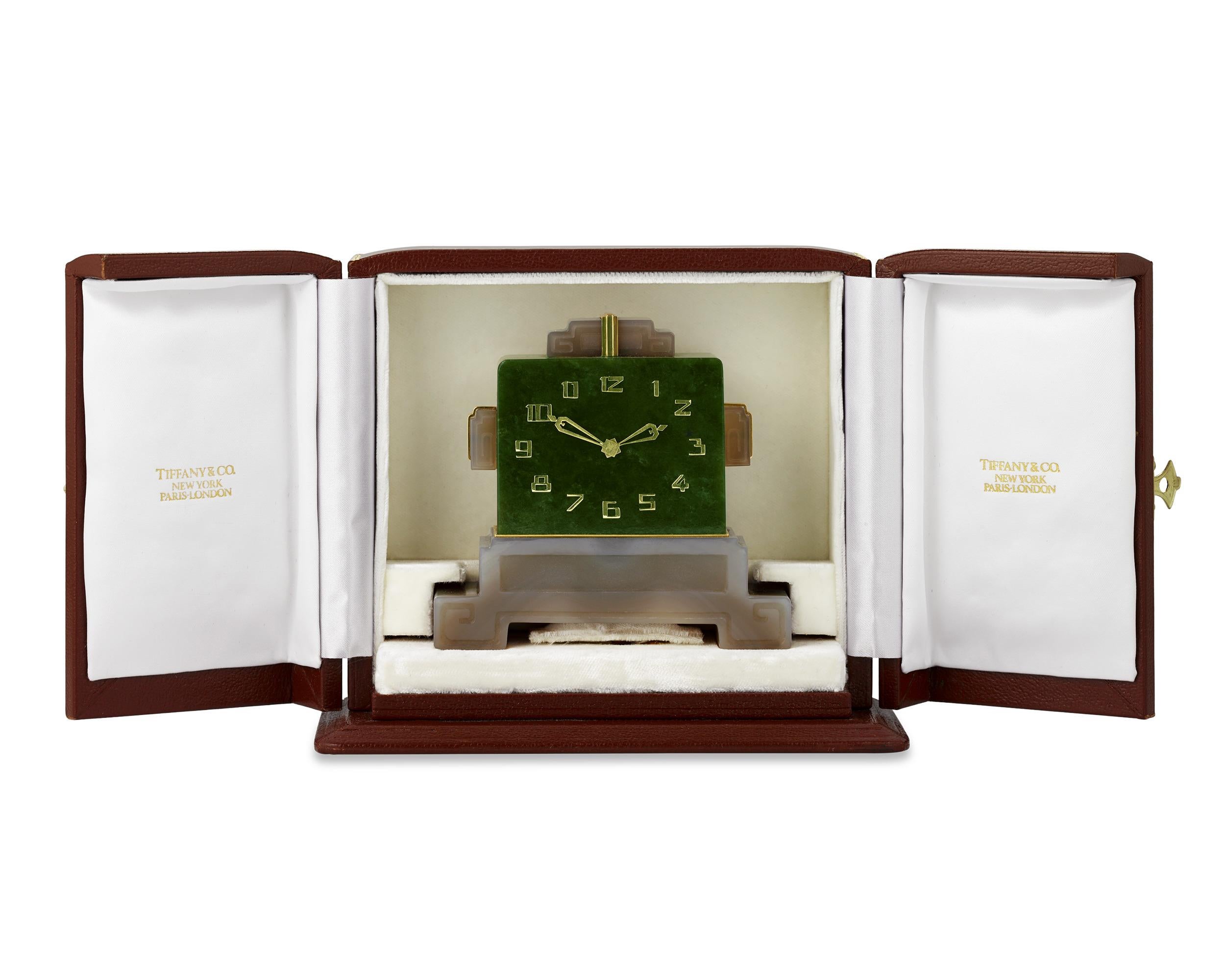 Exuding the timeless grandeur of the Art Deco period, this Tiffany & Co. France travel clock is composed of luxurious nephrite jade and quartz. The angular design of the timepiece's body incorporates squared scrolling motifs, heightening the