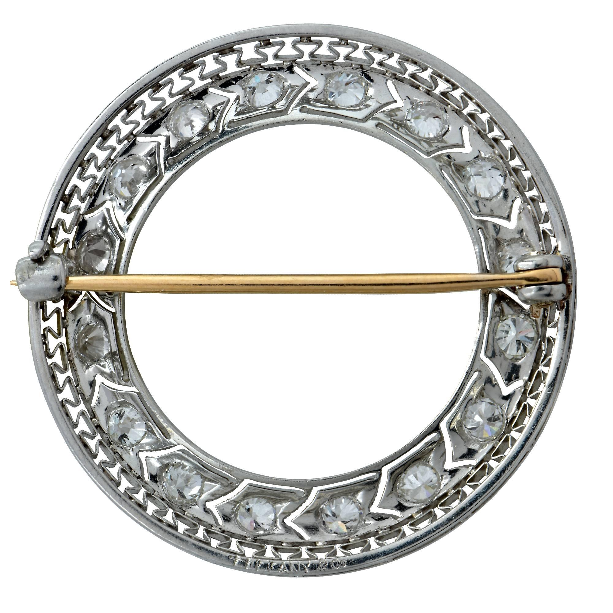 Exquisite Tiffany & Co. Art Deco brooch pin crafted in Platinum featuring 16 old european cut diamonds, G color VS quality weighing 1 carat total weight with beautiful intricate millegraine and geometric filigree work set in a circle. This rare