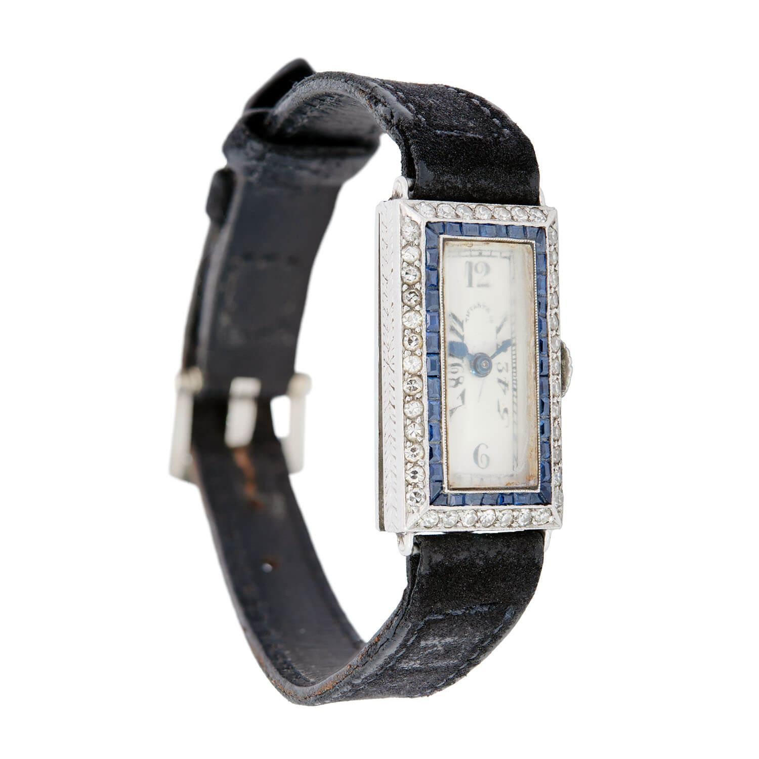 Une superbe montre de l'époque Art déco (vers les années 1930) du légendaire joaillier Tiffany and Co ! Réalisé en platine, le boîtier de la montre est orné d'une rangée de saphirs de taille française sertis en canal, qui présentent une belle teinte