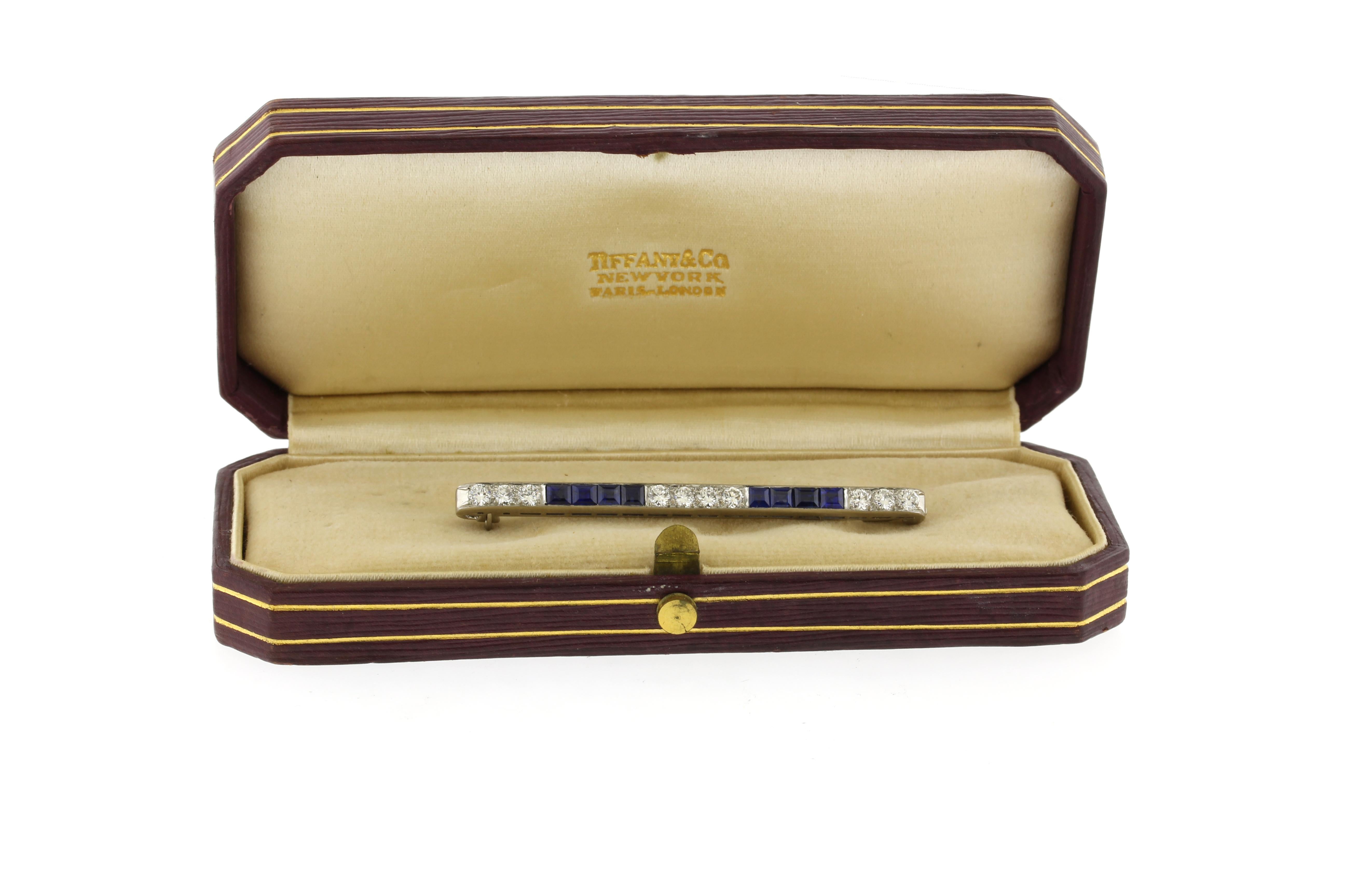 Questa Tiffany & Co. La spilla in platino Art Deco sembra squisita! Con 10 diamanti per un totale di 0,90 carati, di colore D-E e purezza VS, abbinati a 8 zaffiri quadrati blu reale per un totale di 1,40 carati, è un pezzo straordinario. L'elegante