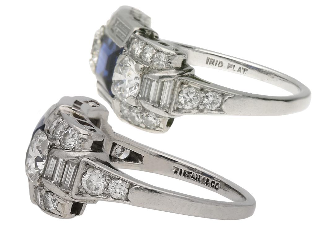 Tiffany & Co. Art Deco sapphire and diamond ring. Centrally set with a rectangular step cut natural unenhanced sapphire in an open back tension setting with an approximate weight of 0.80 carats, flanked by two round old cut diamonds in open back