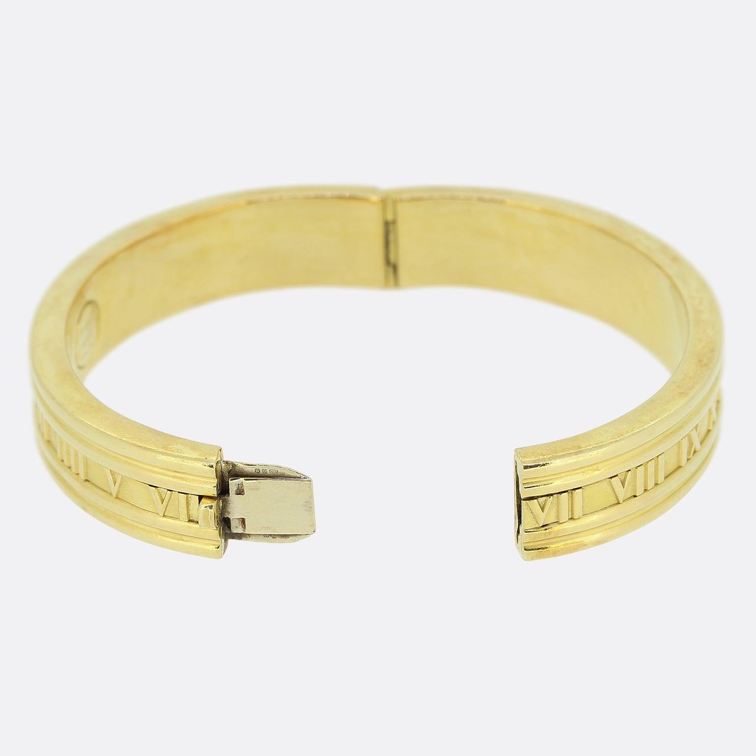 Here we have an 18ct yellow gold bangle from the luxury jewellery designer Tiffany & Co. The bangle forms part of the atlas collection and features the iconic Roman numeral design around the bracelet. 

Condition: Used (Excellent)
Weight: 44.5