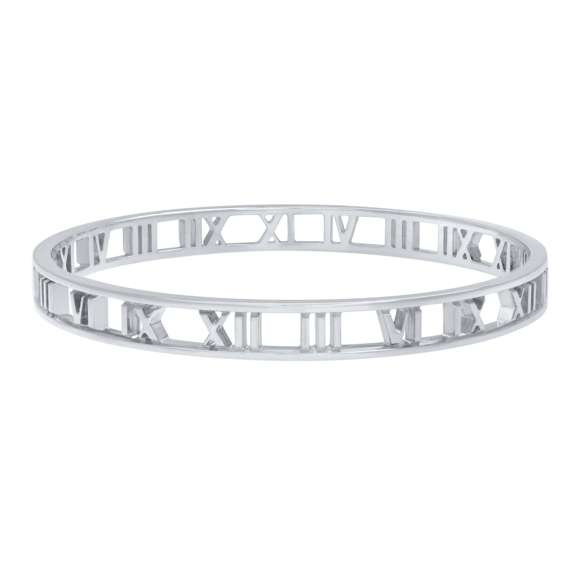 A Tiffany & Co. sterling silver bracelet from the Atlas collection. This bangle style bracelet features Roman numerals set in an openwork design. Fits wrist 5.75 inches. Excellent pre-owned condition. The bracelet is accompanied by a Tiffany & Co.
