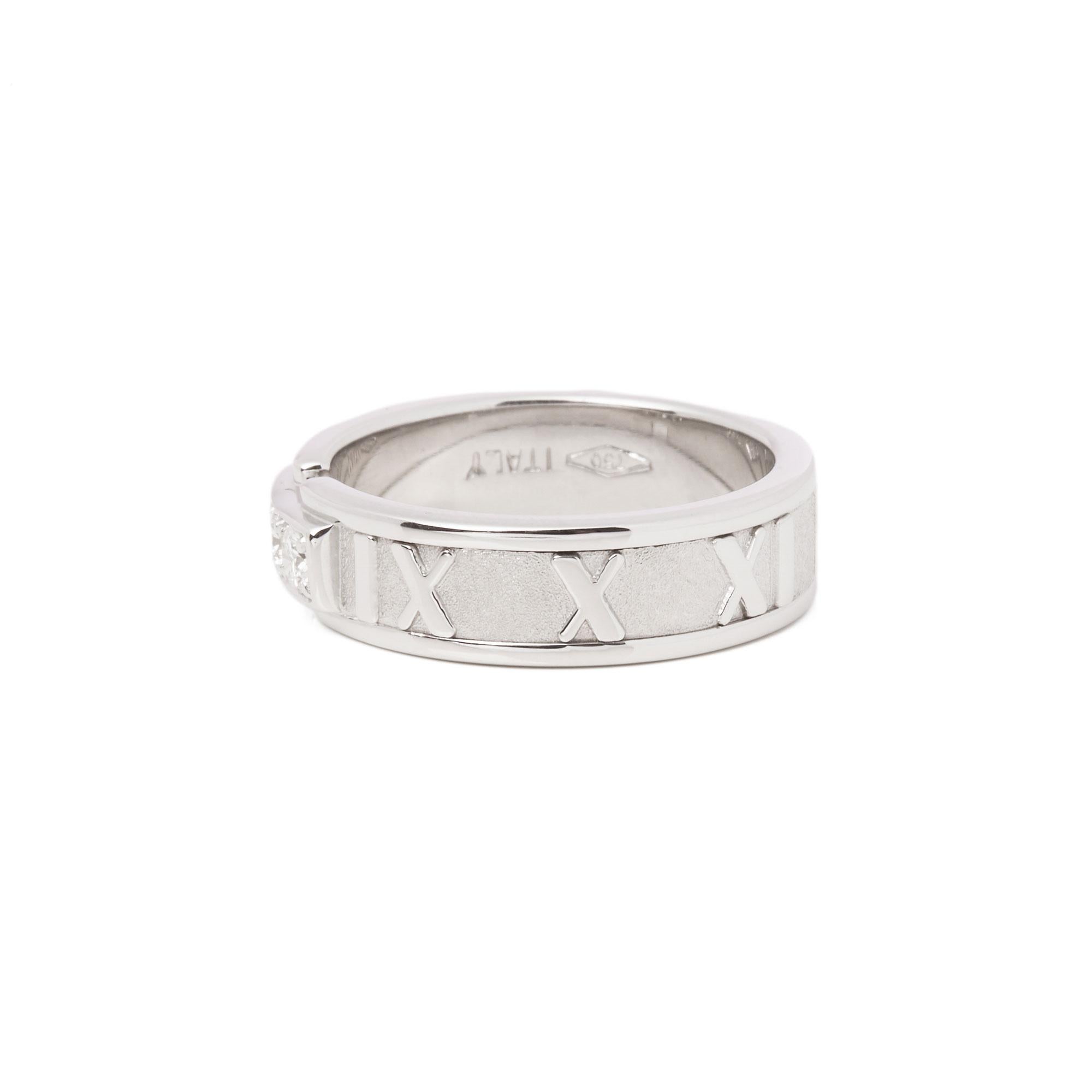 This ring by Tiffany & Co is from their Atlas collection and features 3 round brilliant cut diamonds set within an 18ct white gold band ring. The band features the iconic Roman numeral design accentuated by the contrast of highly polished and