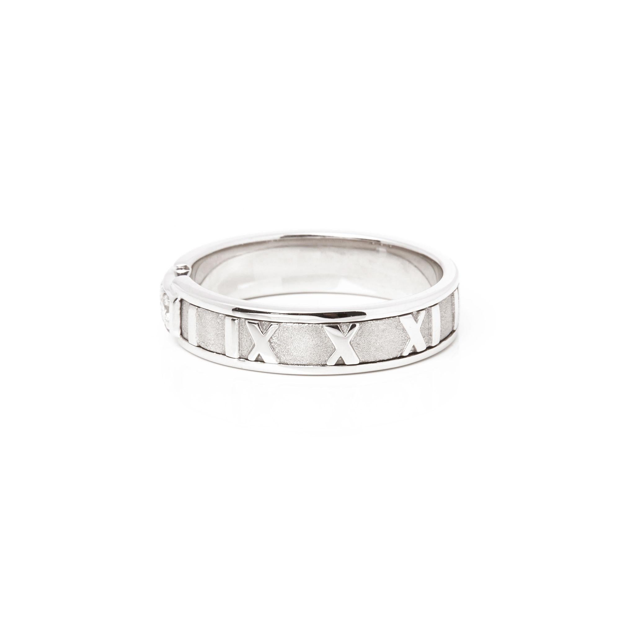 This ring by Tiffany & Co is from their Atlas collection and features 3 round brilliant cut diamonds set within an 18ct white gold band ring. The band features the iconic Roman numeral design accentuated by the contrast of highly polished and