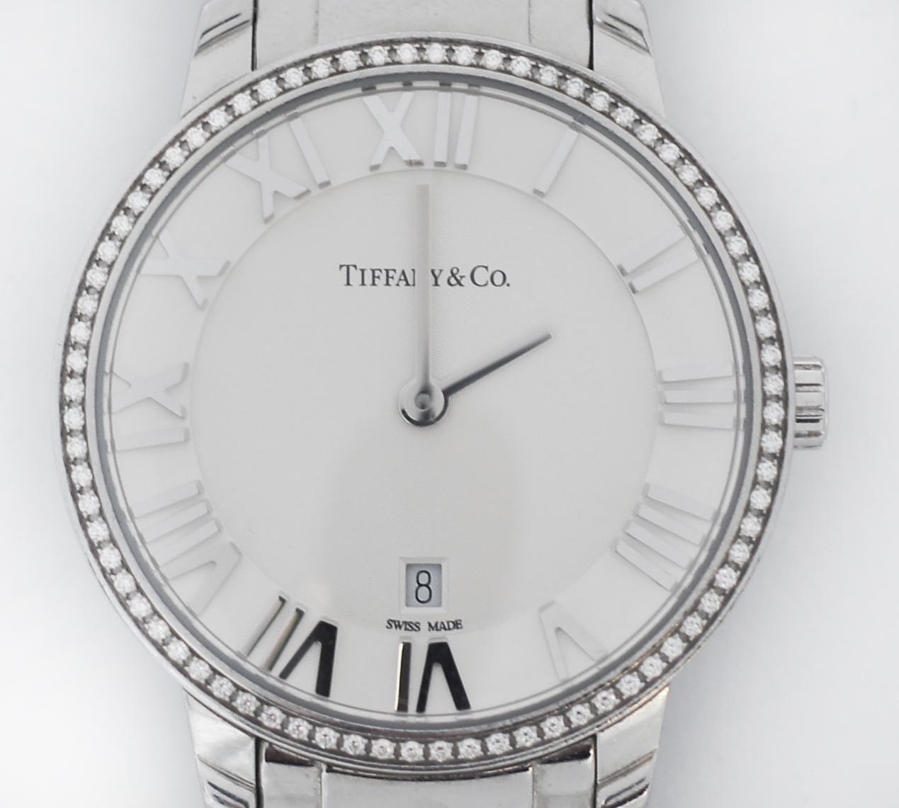 Beautiful Tiffany & Co. Atlas Stainless Steel Watch
stainless steel case and bracelet.
Beautiful fixed single row round brilliant Diamonds bezel.
Approximate Diamond carat total weight .14
Silver azure dial with Roman numeral markers and date window