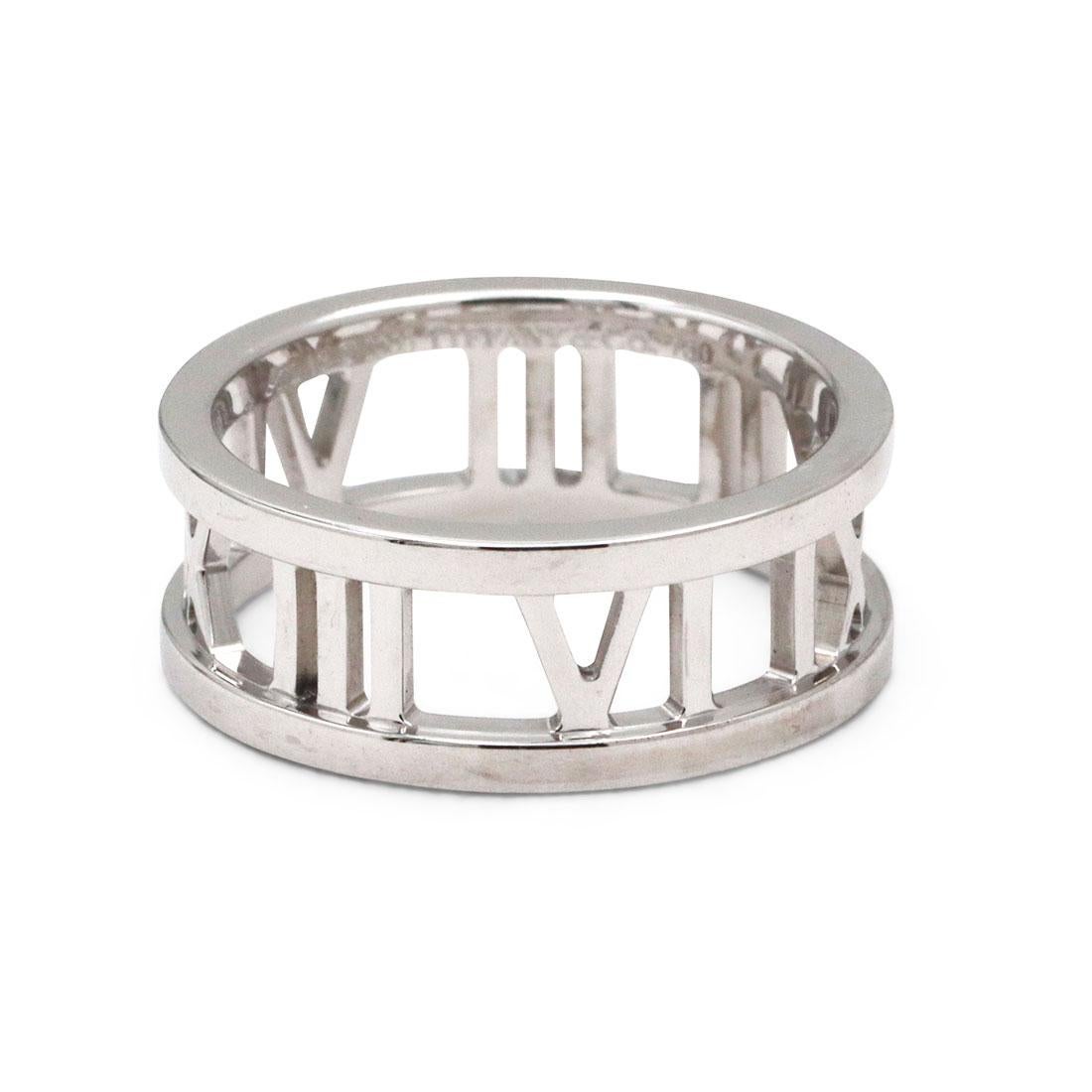 Authentic Tiffany & Co. Atlas ring, crafted in 18 karat white gold.  This classic ring is designed as a band and features Roman numeral designs. The band measures 6.8mm wide. Size 4 1/2. Signed Tiffany & Co, Atlas, 2003, 750. This ring is not