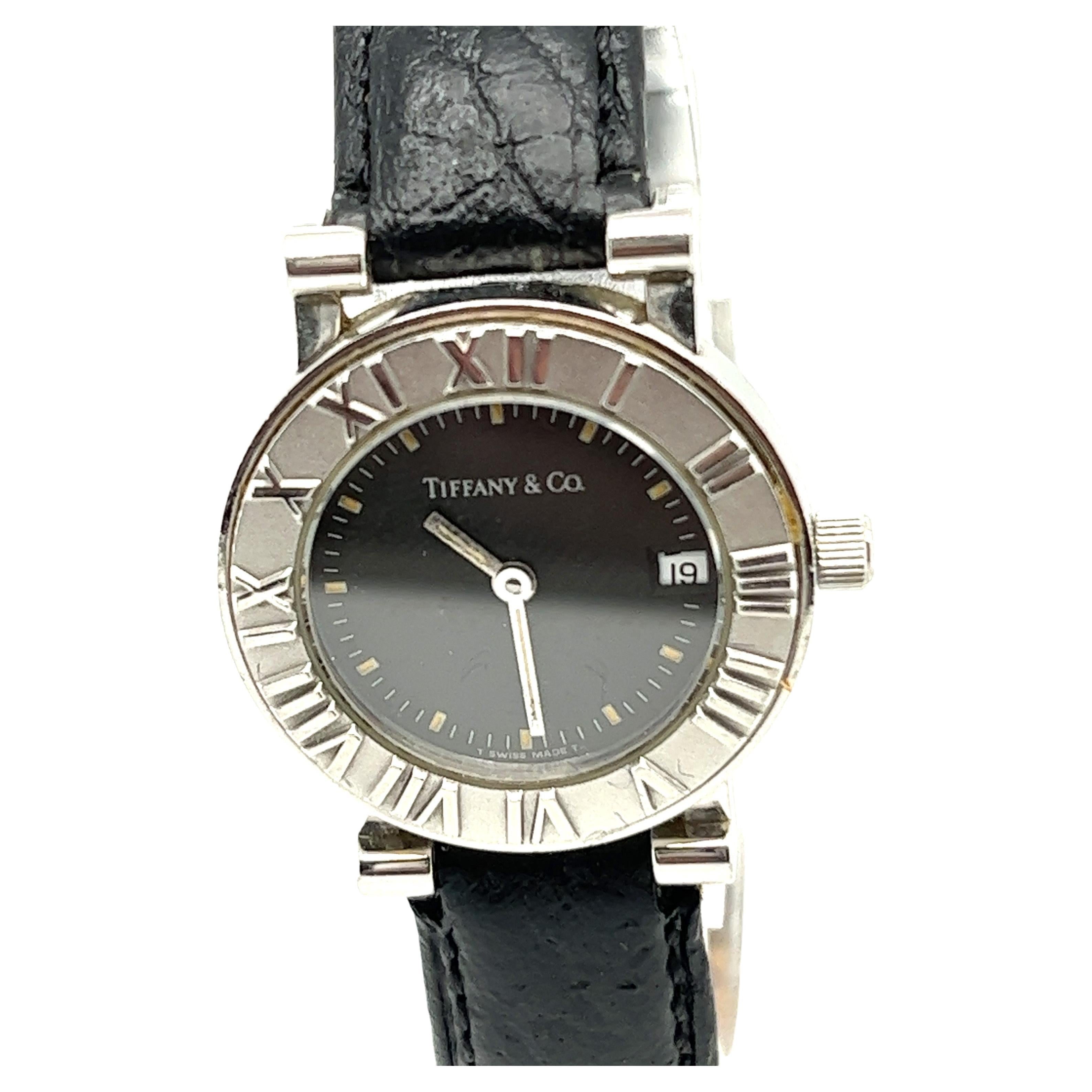 Collectional by Tiffany & Co, cette montre fait partie de la collection Atlas, qui s'inspire de l'horloge qui se trouve devant le magasin phare de New York. Fabriqué en acier inoxydable avec un bracelet en crocodile. Elle est gravée de chiffres