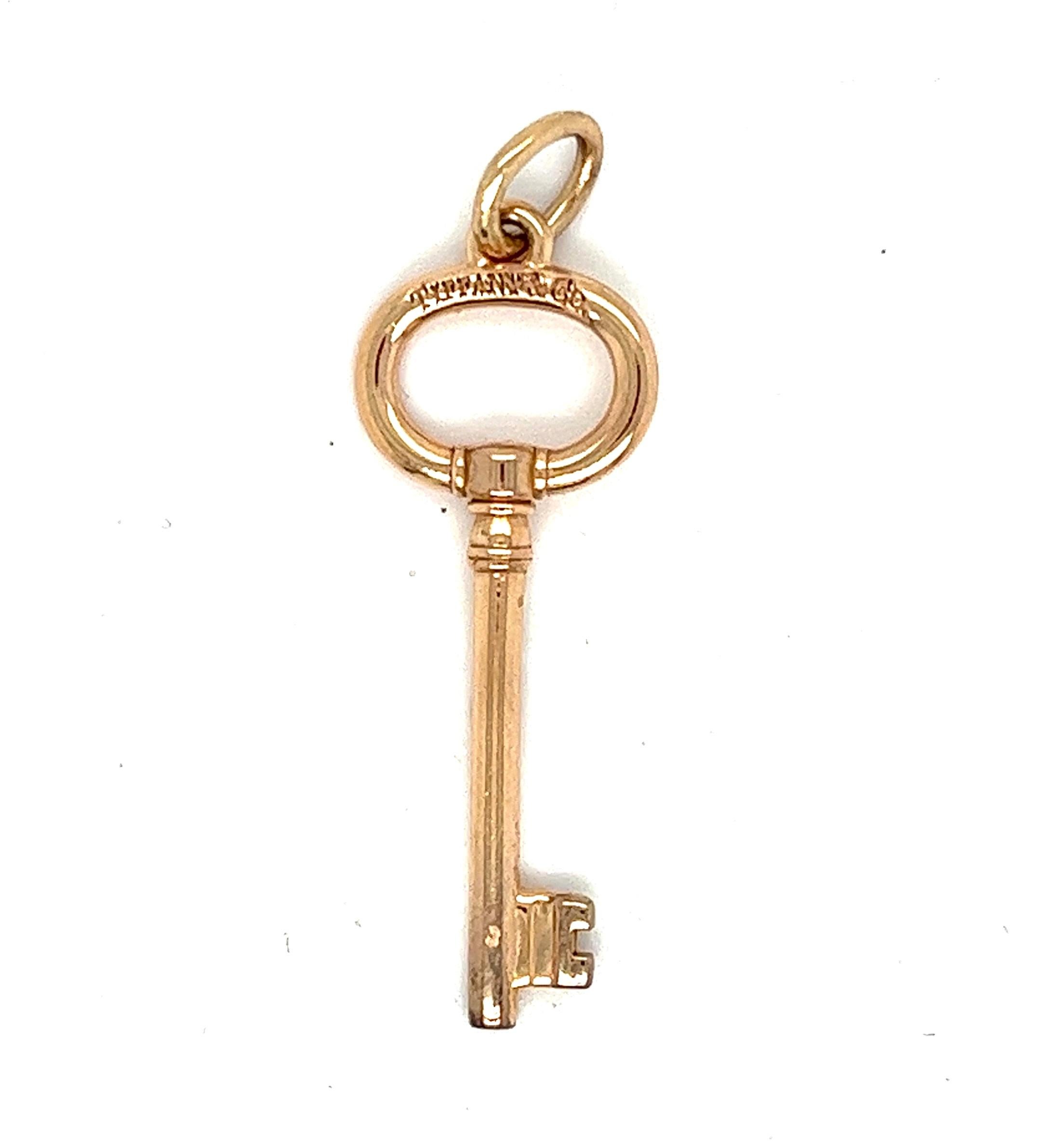 Tiffany & Co. Authentic Open Round Key Pendant - 18kt Rose Gold

Unlock elegance with the iconic Tiffany & Co. Open Round Key Pendant in exquisite 18kt rose gold. This timeless piece embodies sophistication and luxury, showcasing Tiffany's renowned