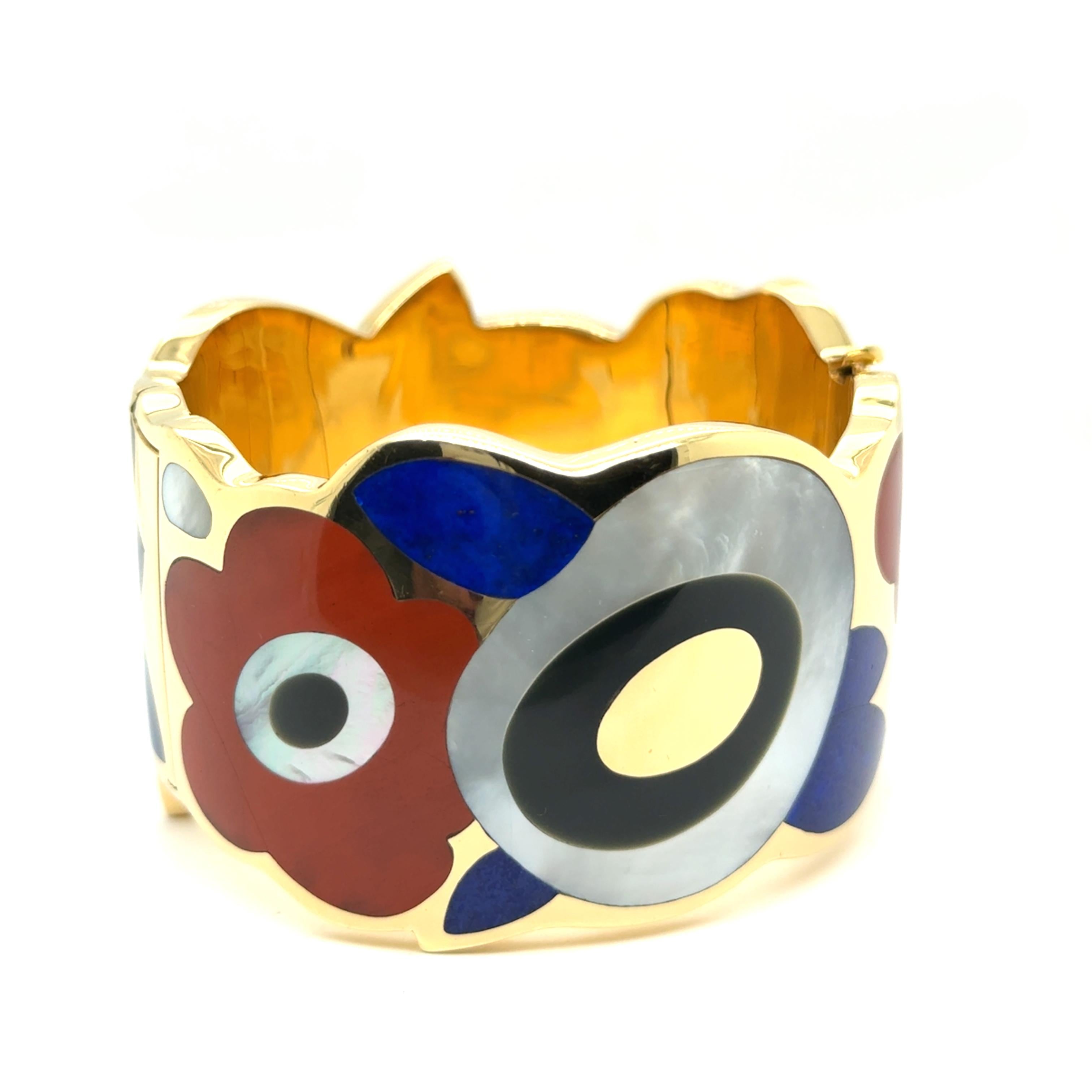 Discover the luxurious Angela Cumming for Tiffany armband, crafted in 18 Karat yellow gold and adorned with vibrant gemstones. This exquisite piece features a delicate floral print, merging timeless elegance with a splash of colour. 

With a