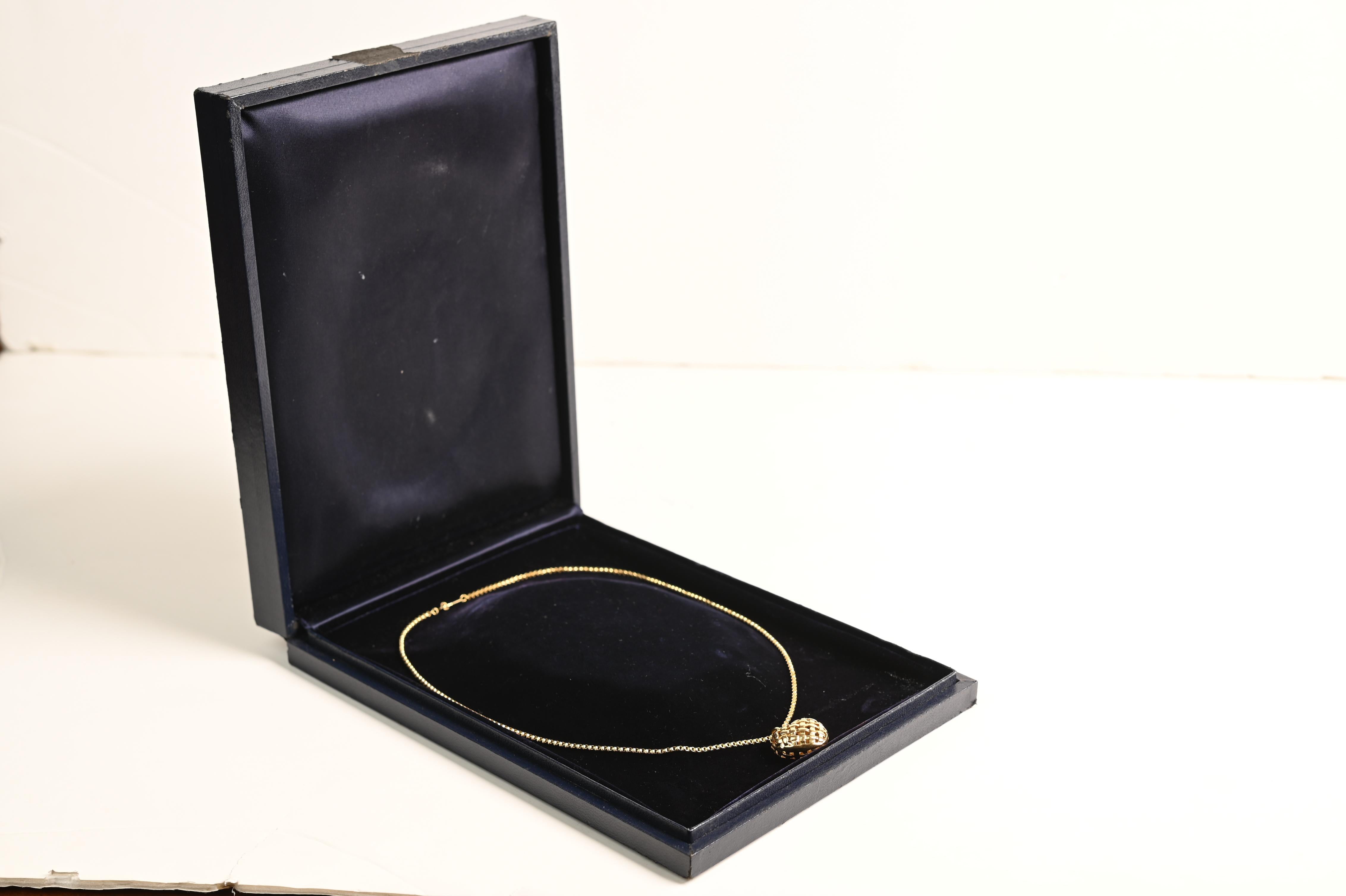 This exquisite Tiffany & Co. necklace showcases the brand’s signature elegance through a striking basket weave pendant, delicately sculpted into an open, domed heart shape. A masterclass in craftsmanship, the intricate design captures a sense of