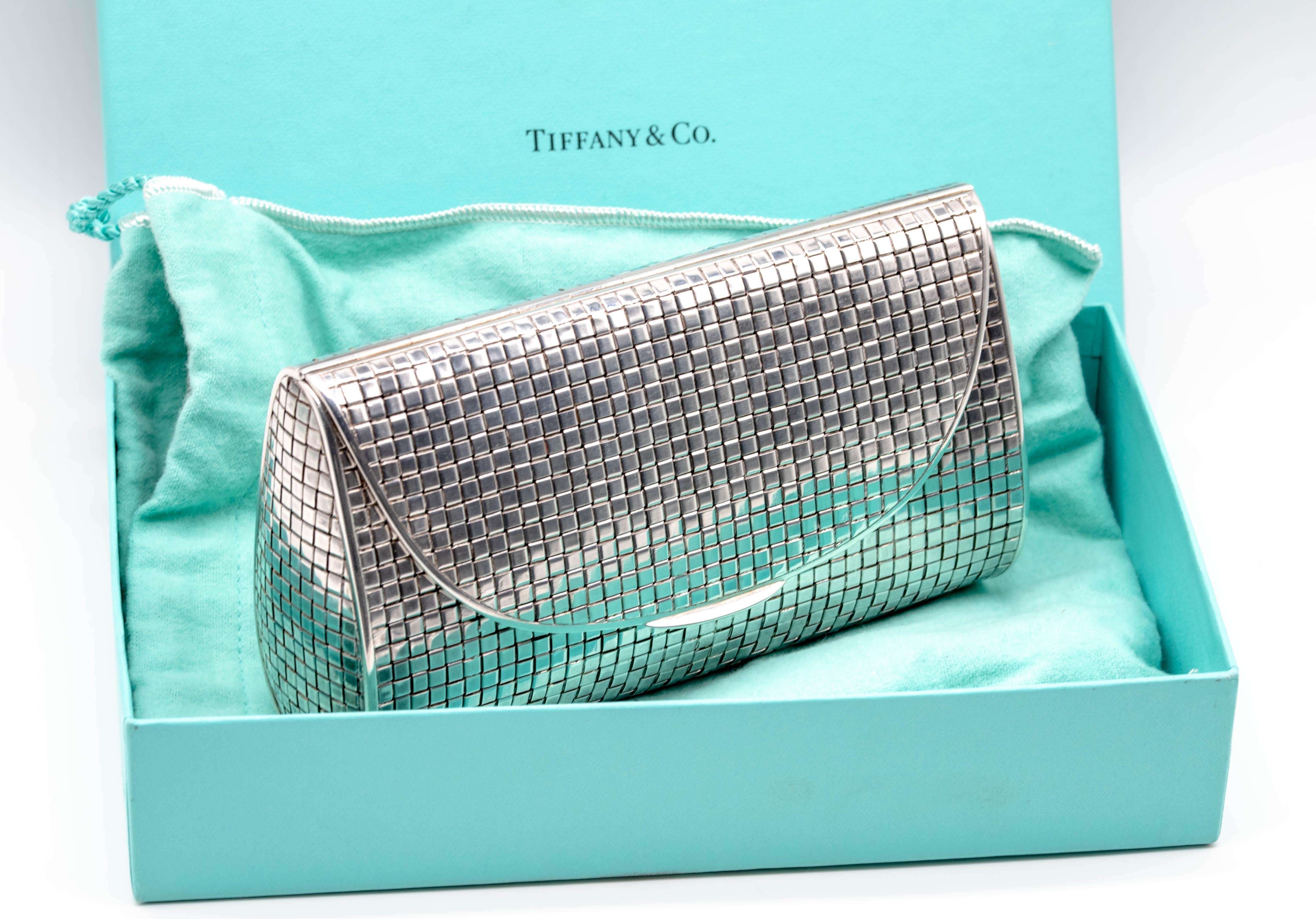 A covetable clutch from the venerable firm of Tiffany & Co, this adorable little purse can contain a surprising amount of evening necessities.  The snap closure pulls up on the dual hinges at the sides and when you access the inside, you can