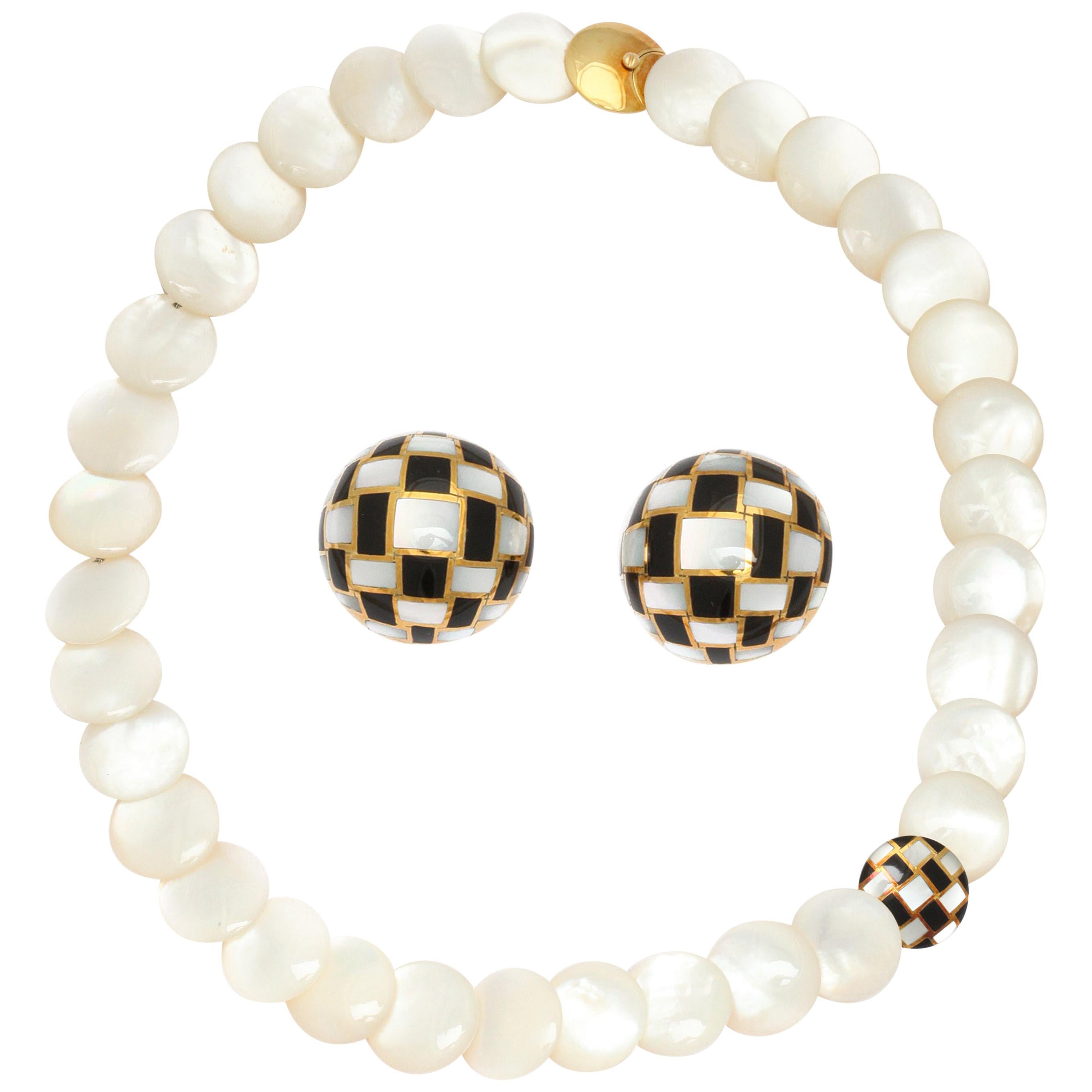 Simply chic for any age, a Tiffany & Co. necklace of carved mother-of-pearl disks with 18K gold clasp and a perfectly placed checkered disk of pearl and black jade inlay with matching ear clips. Necklace measures 3/4 inch x 20 inches long weighing