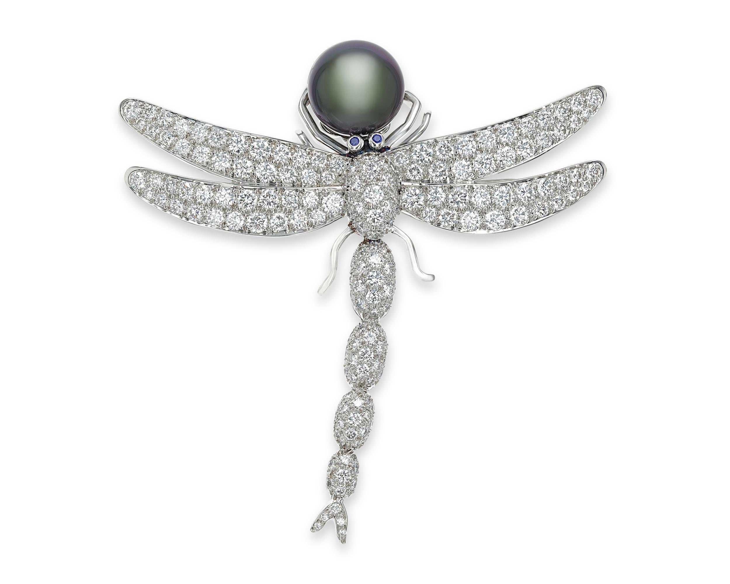 The delicate wings and tail of this dragonfly sparkle with approximately 4.87 carats of diamonds. It grasps a single Tahitian pearl with its front legs, while sapphires highlight its eyes. Crafted by Tiffany & Co., the brooch displays both the