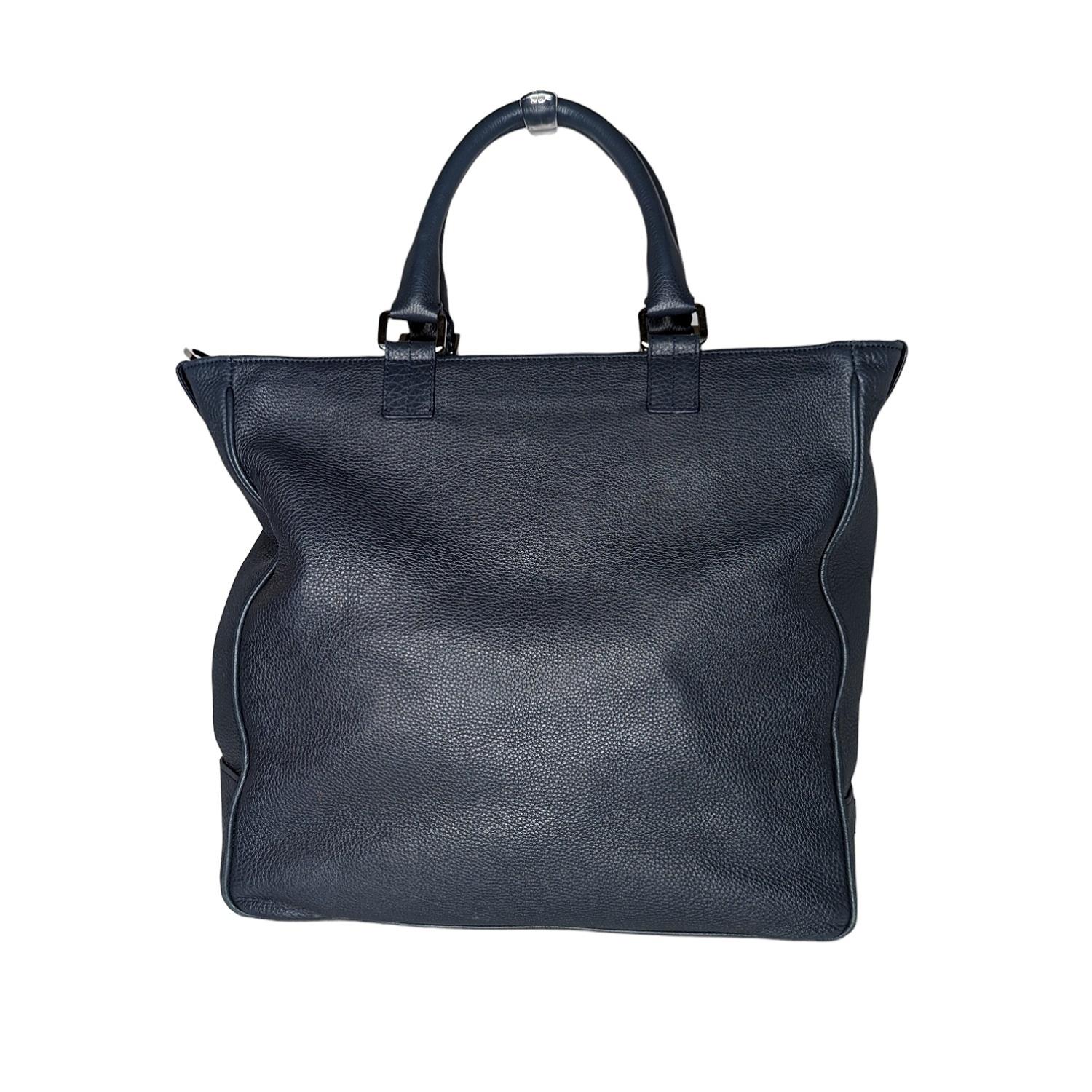 Tiffany & Co. Blake Convertible Tote Leather is an elegant everyday staple. Crafted from supple navy pebbled leather, this oversized tote features dual-rolled leather handles, exterior front zip pocket, and silver-tone hardware accents. Its top zip