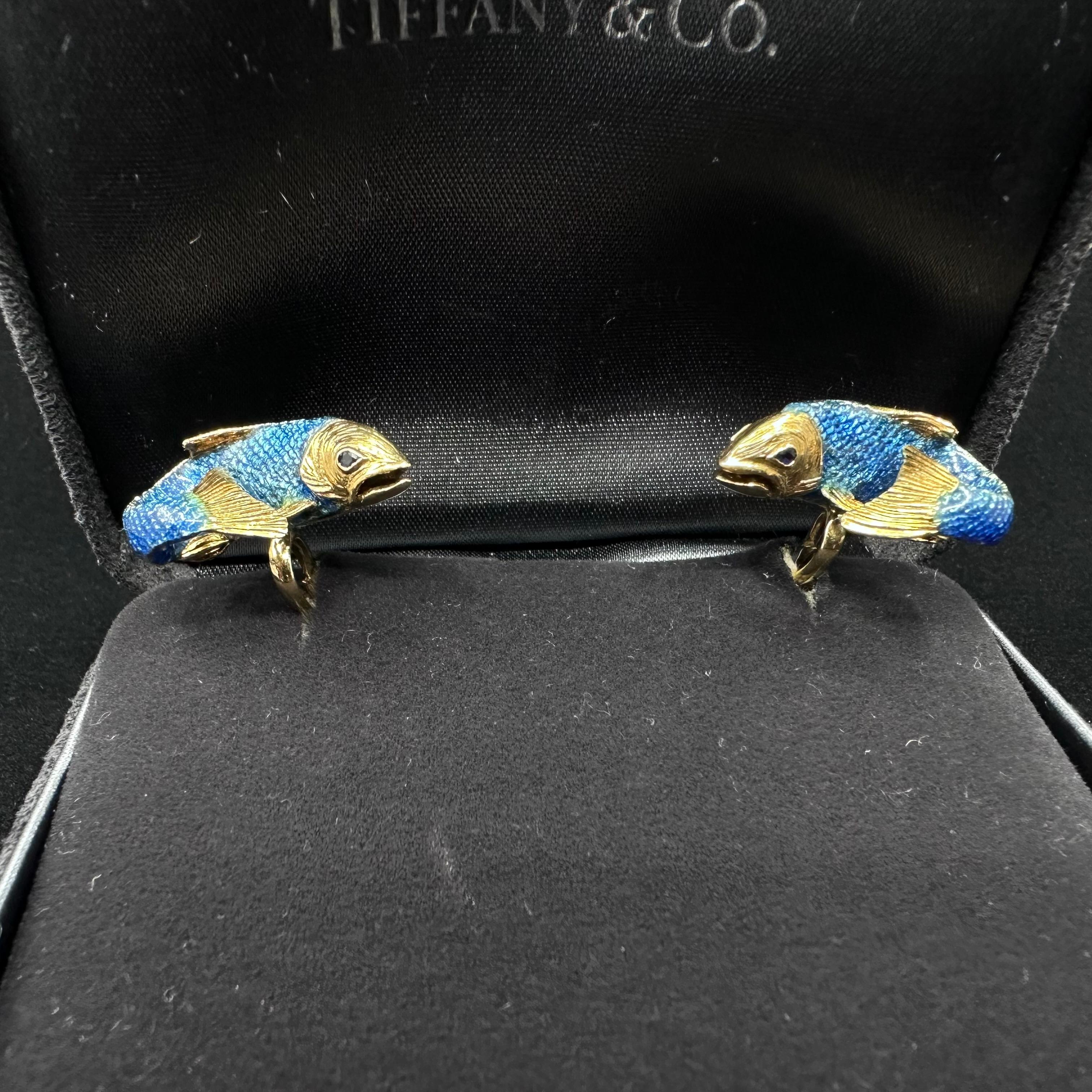 Tiffany & Co Enameled Trout Cufflinks 
Hallmarked Tiffany 750 C Germany
Weight 22 g
Length .90 inch 
width .50 inch 
Rare Tiffany Cufflinks Beautiful blue enameled trout motif 18k yellow gold.  The findings are designed as a fishhook with faceted