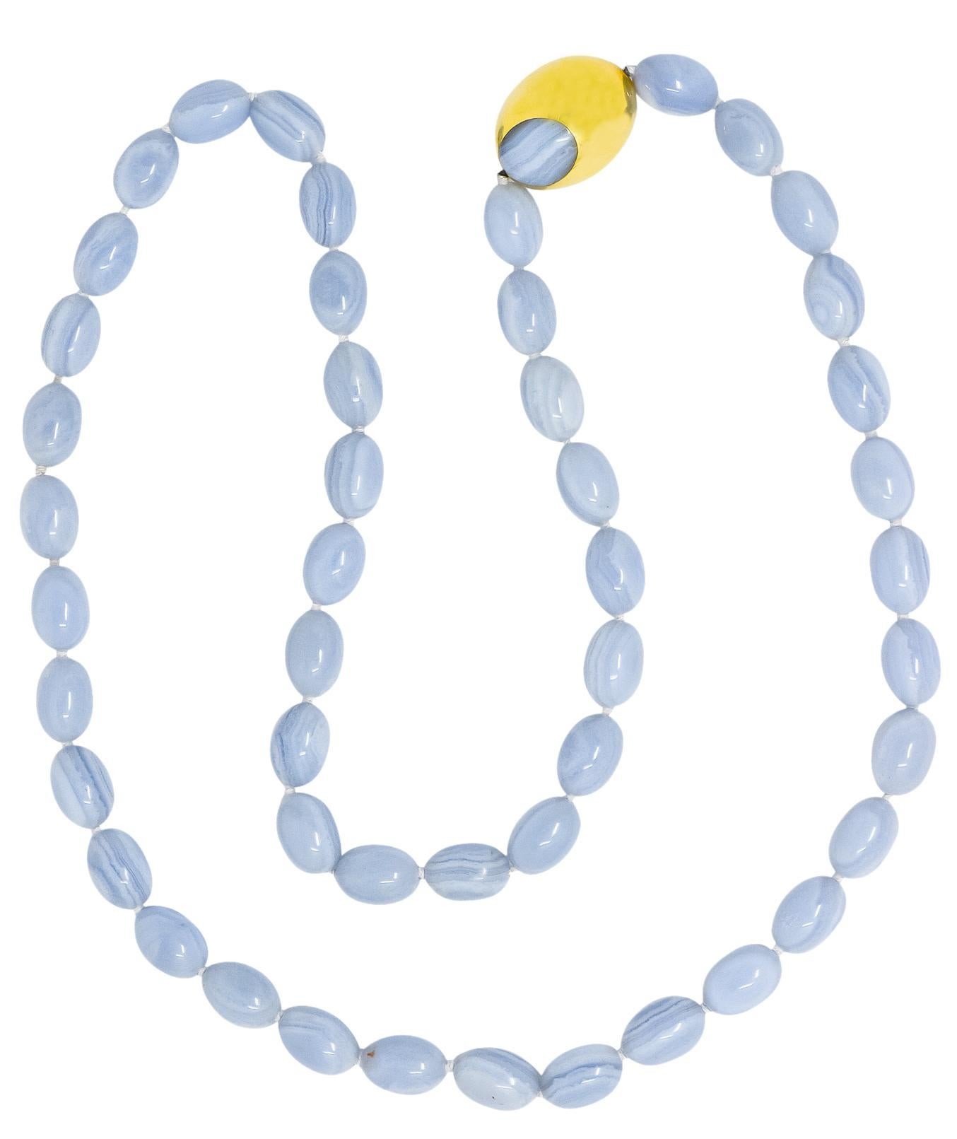 Featuring forty-eight oblong polished blue lace agate beads, measuring approximately 17.0 x 12.0 mm

High polished with swirling light blue and white

With a large hollow oblong gold bead containing two inset oval blue lace agate sections 

Fully
