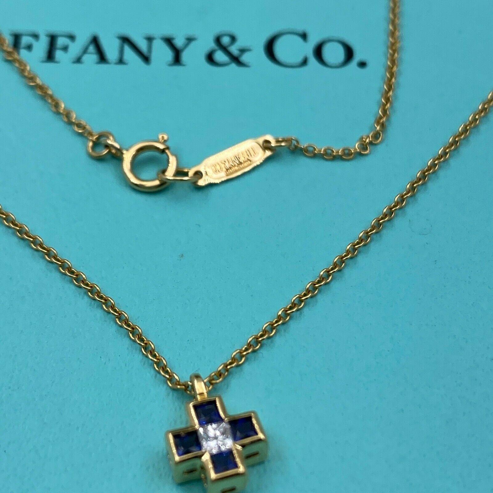 Tiffany & Co. Cross Pendant Necklace
Style:  Pendant Necklace
Metal:  18kt Yellow Gold
Size:  16 inches
Pendant:  9 MM
Main Diamond:  Princess Cut Diamond 0.08 pts
Gemstone:  4 Blue Square Cut Sapphires
Hallmark:  TIFFANY&CO.750 on Chain & T&Co.750