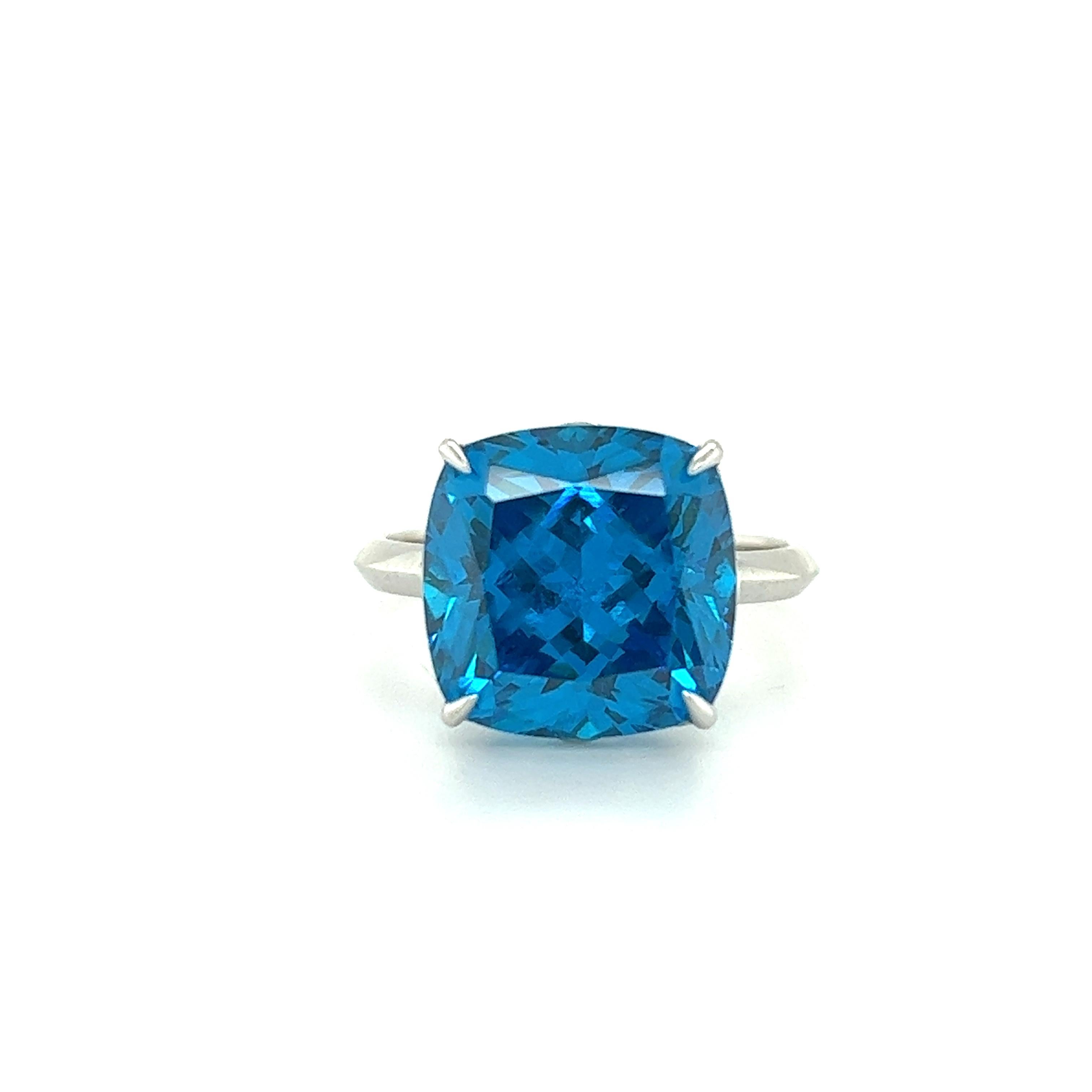 Beautiful ring crafted by famed designer Tiffany & Co. The ring is crafted in 18k white gold and highlights one electric colored blue topaz gemstone.  The design is simple, yet elegant as small details truly make this ring stand out. Sharp eagle