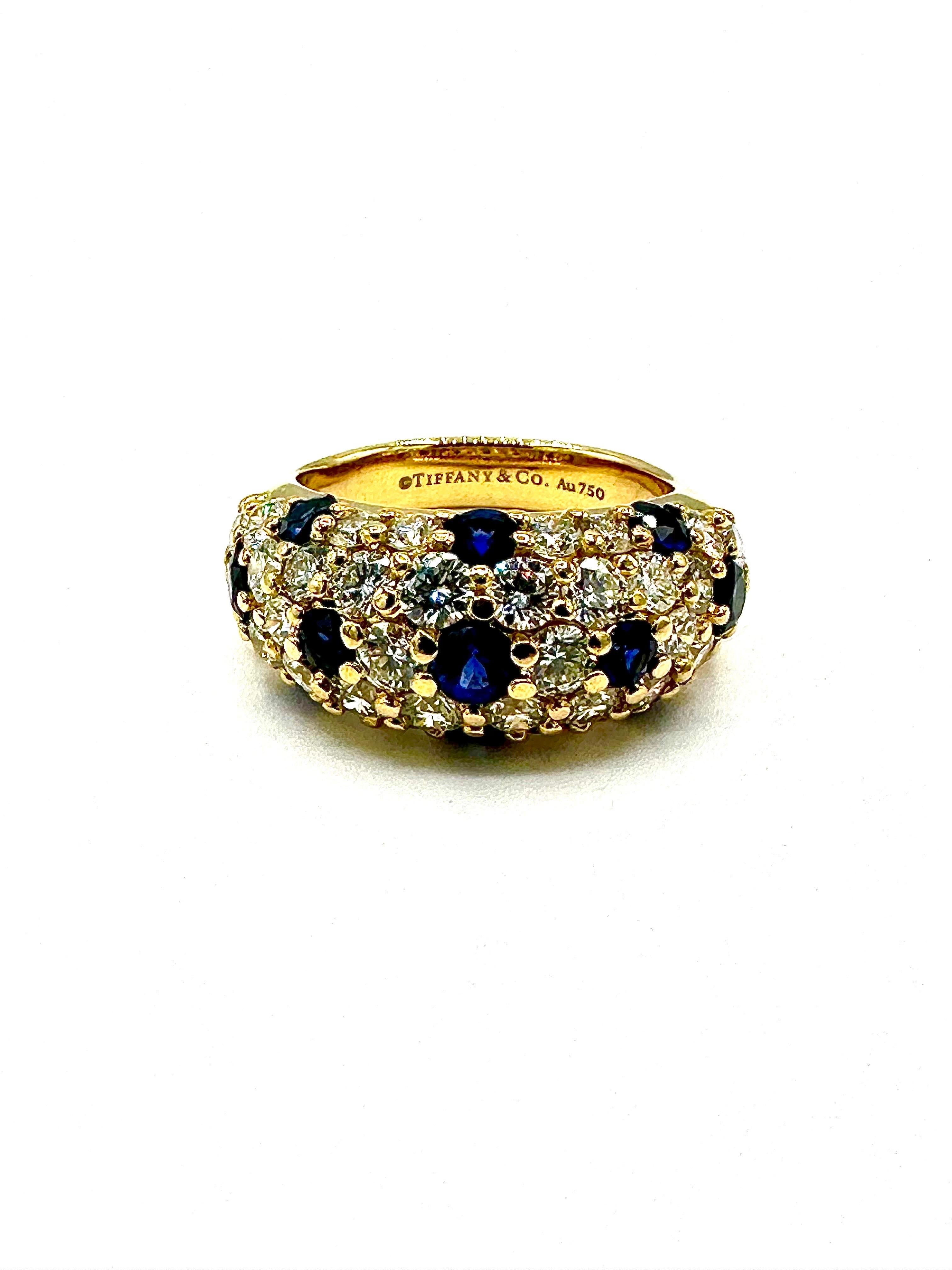 A gorgeous Tiffany & Co. Bombe style Diamond and Sapphire band ring.  The ring features 33 round brilliant cut Diamonds, with 11 blue Sapphires set throughout the ring.  The Diamonds have a total weight of 1.90 carats, with 0.65 carats in Sapphires,