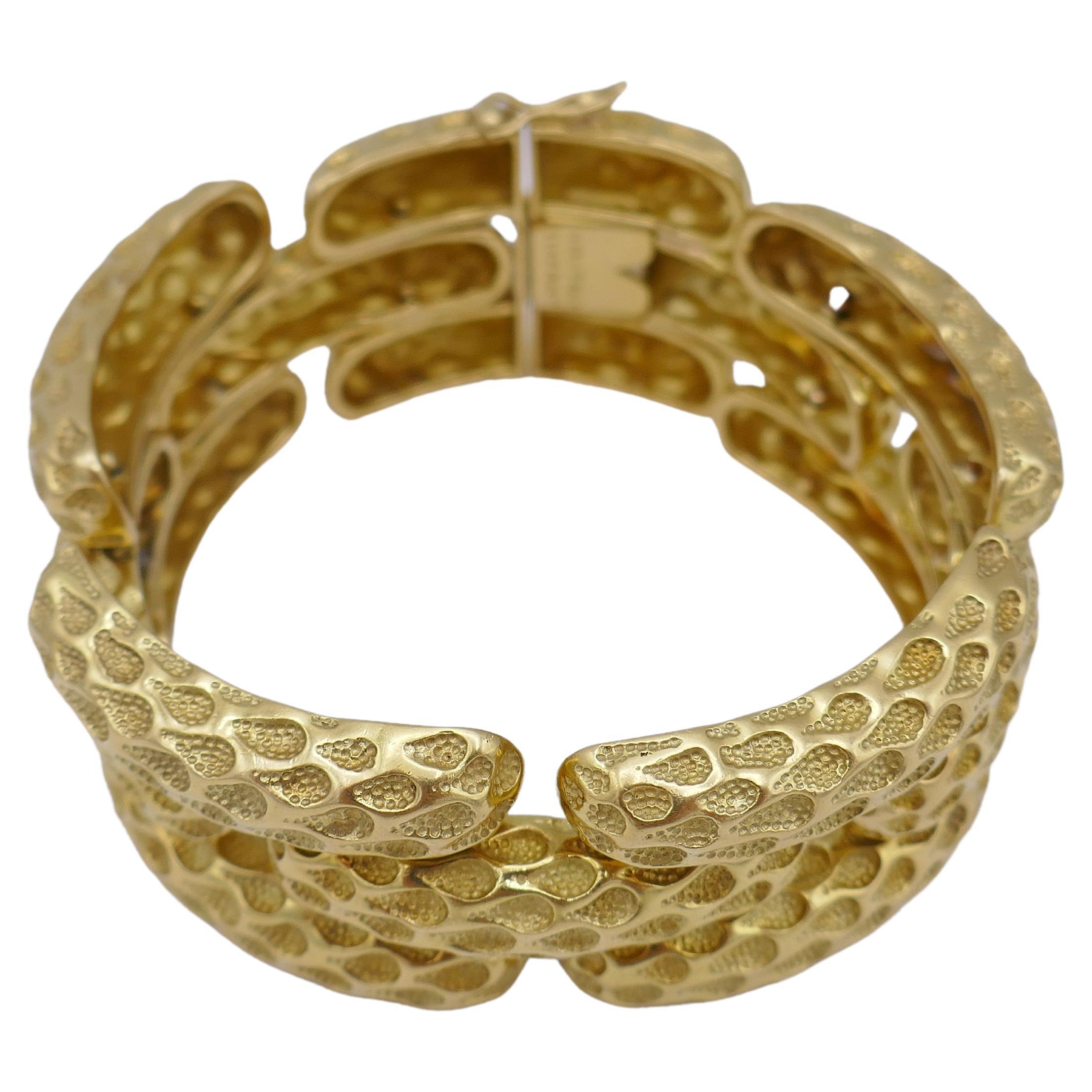 Ein erstaunliches Armband von Tiffany & Co. aus 18k Gold. Mit einem perfekt gearbeiteten, gehämmerten Schlangenhautmotiv.
Das Armband besteht aus ovalen Goldteilen, die sphärisch in Form eines Handgelenks gebogen sind. Es gibt drei Reihen dieser