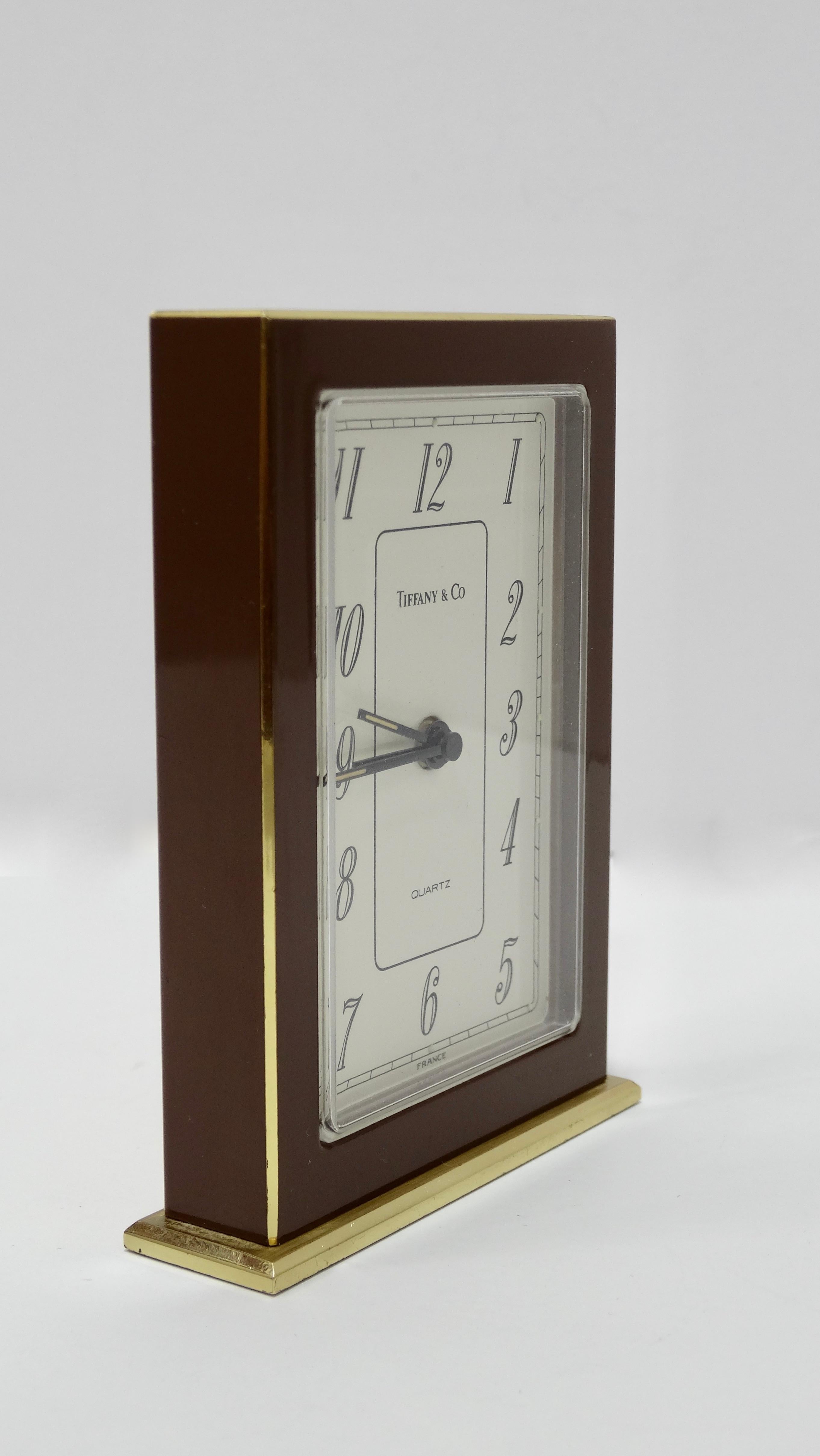 Elevate your desk with this Tiffany & Co. clock! Circa 1960s and made in France, this simple art deco brass desk clock is a slim rectangular shape quartz movement and features brown enamel with a white face and black numbers for a clean and timeless