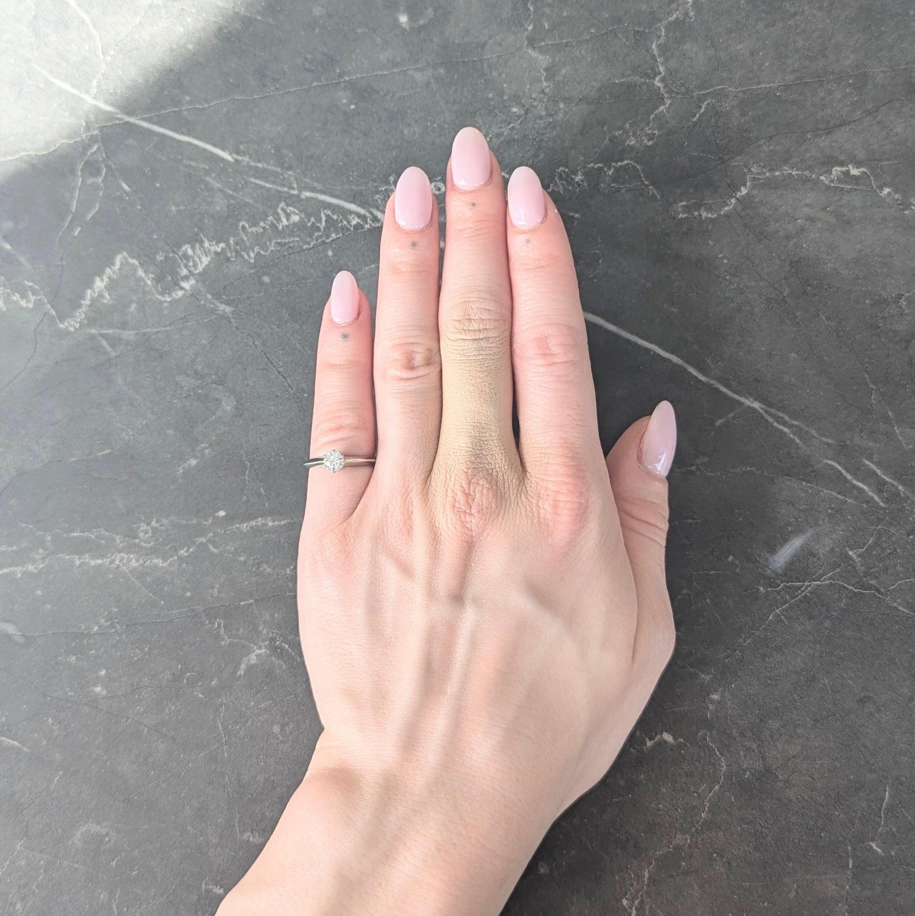 Centering a round brilliant cut diamond weighing 0.39 carats - G color with VS1 clarity
Set in a six pronged classic Tiffany style mounting
Flanked by knife edge shoulders
Inscribed 'S to Y'
Inscribed with carat weight
Stamped for platinum
Numbered