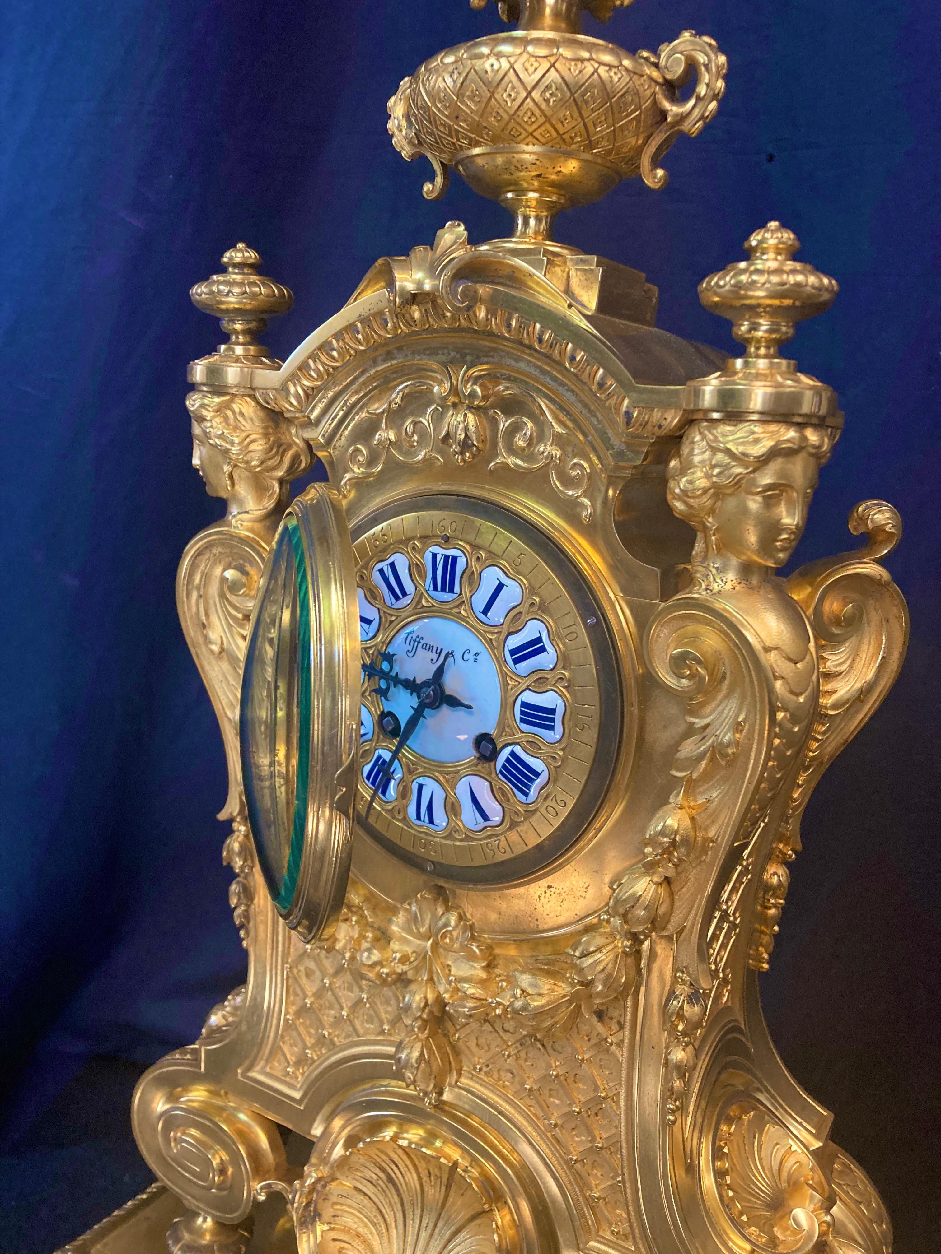 This vintage Tiffany & Co. French bronze clock dates from the late 19th century (1896). It is elaborately designed in the style of Louis XV & exhibits a meticulous detailed casting with distinct sculpted embellishments. A hinged beveled glass door
