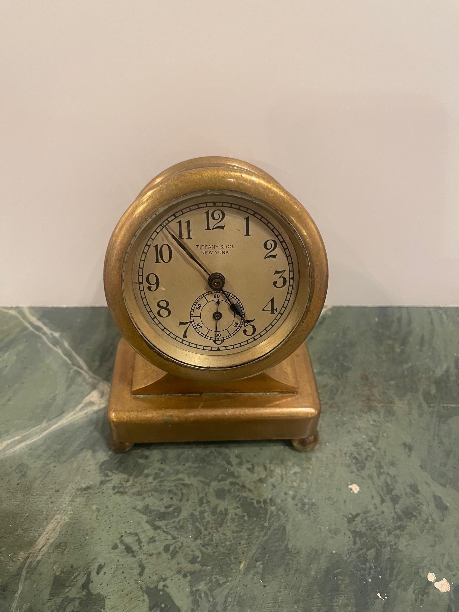 Tiffany & Co. bronze desk clock, early 20th century. Heavy bronze case with metal face and engraved Arabic numerals. Marked Tiffany & co New York. Front and back unscrew. Mechanism winds and is functional. Accuracy not tested. Some patination