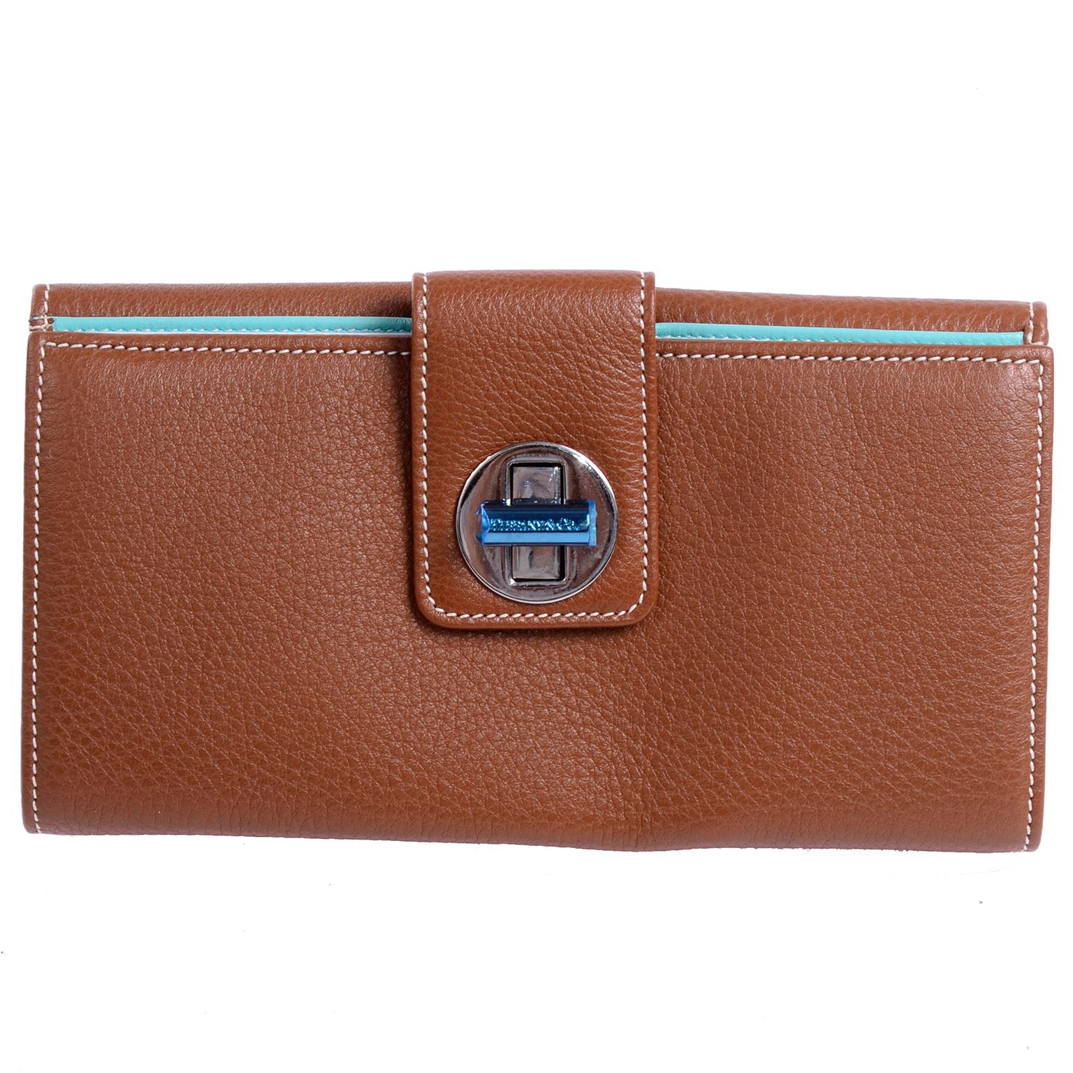 This lovely new Tiffany wallet was never used and comes with its original box and dustbag. The brown pebbled leather wallet still has the original blue plastic over the buckle and all of its original packaging so it would make a perfect gift!  The