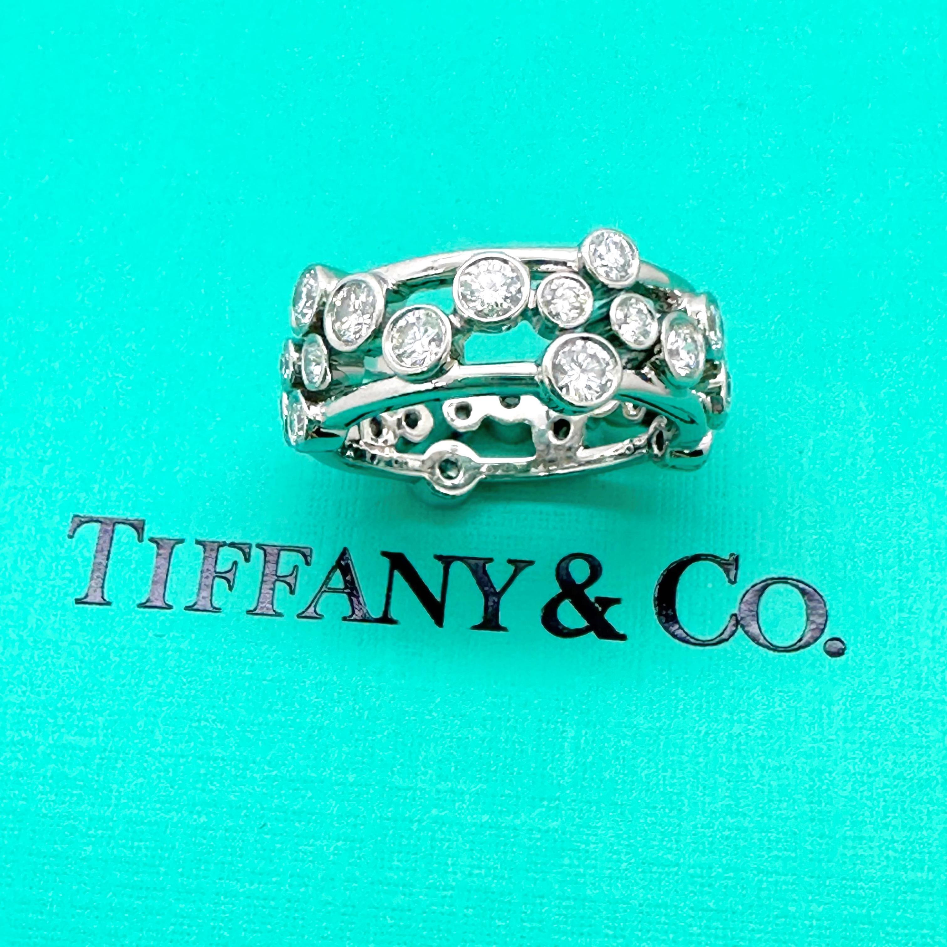 Tiffany & Co. Diamond Platinum Bubbles Band Ring
Style:  Bezel Set Band Ring Circa 2006
Ref. number:  128-21-15735147
Metal:  Platinum PT950
Size:  5.25 
Measurements: 8mm
Main Diamond:  28 Round Brilliant Diamonds
Color & Clarity:  White, Eye Clean