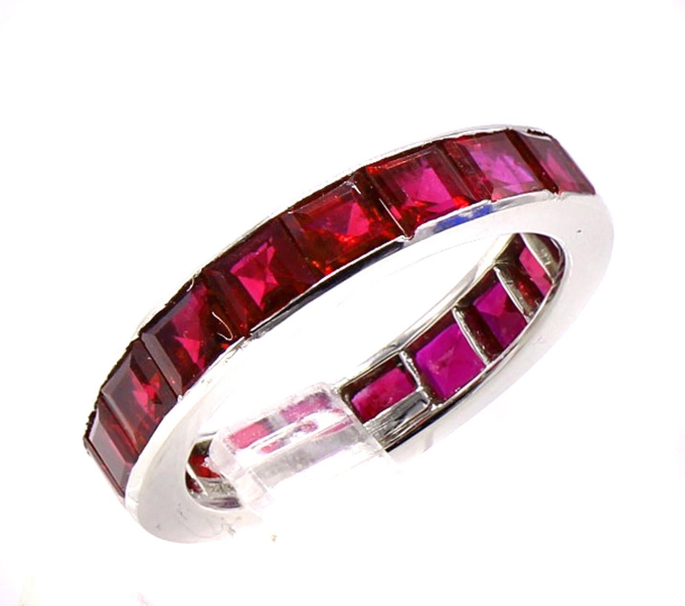 Rare and magnificent platinum eternity band handcrafted by Tiffany & Co. set with 19 perfectly matched step-cut Burma rubies. The rubies display an intensely saturated  