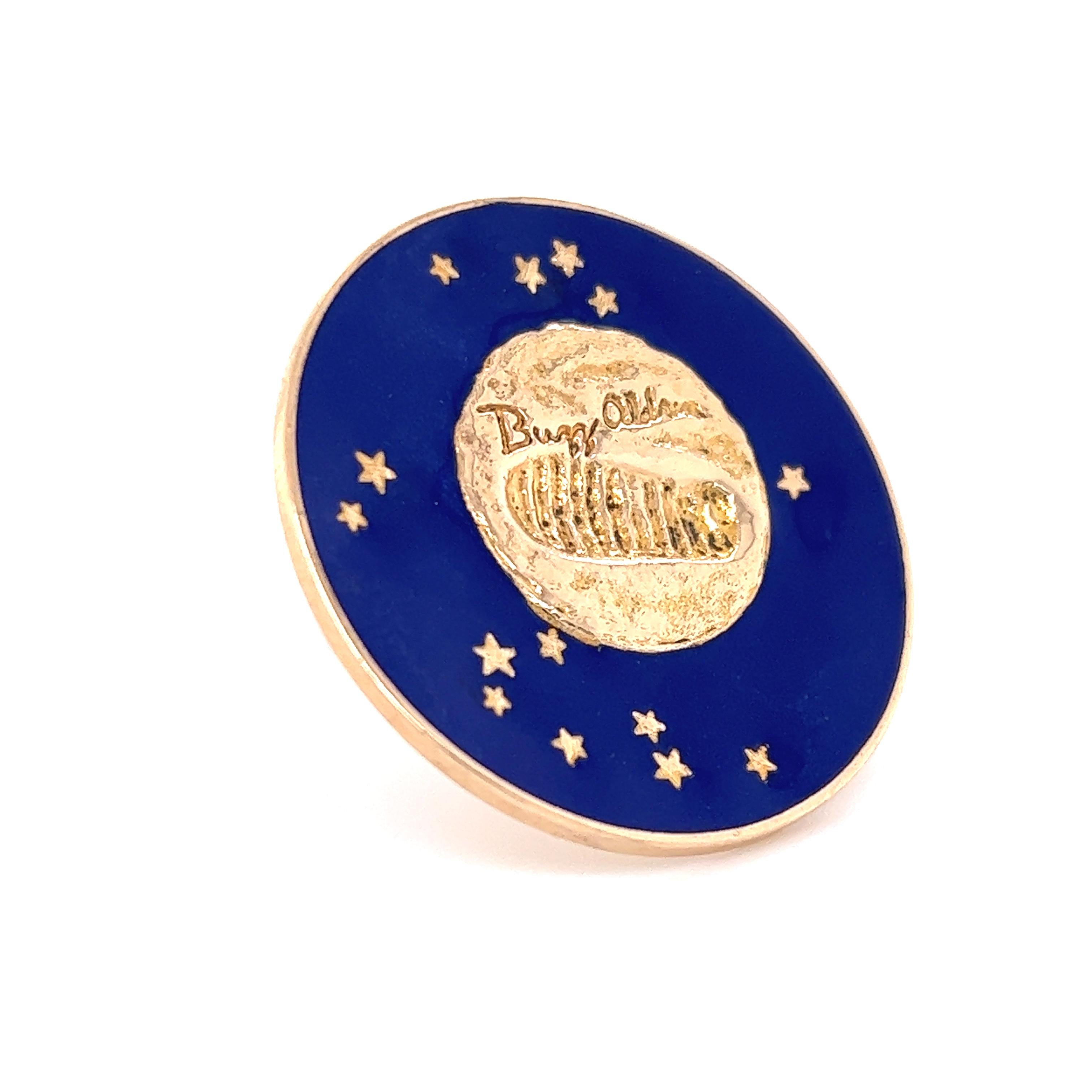 Beautiful 14k yellow gold commemorative pin crafted by Tiffany & Co. The pendant is decorated with a vibrant blue enamel with golden colored stars. The design centers around a representation of a footprint on the moon with a facsimile of Buzz