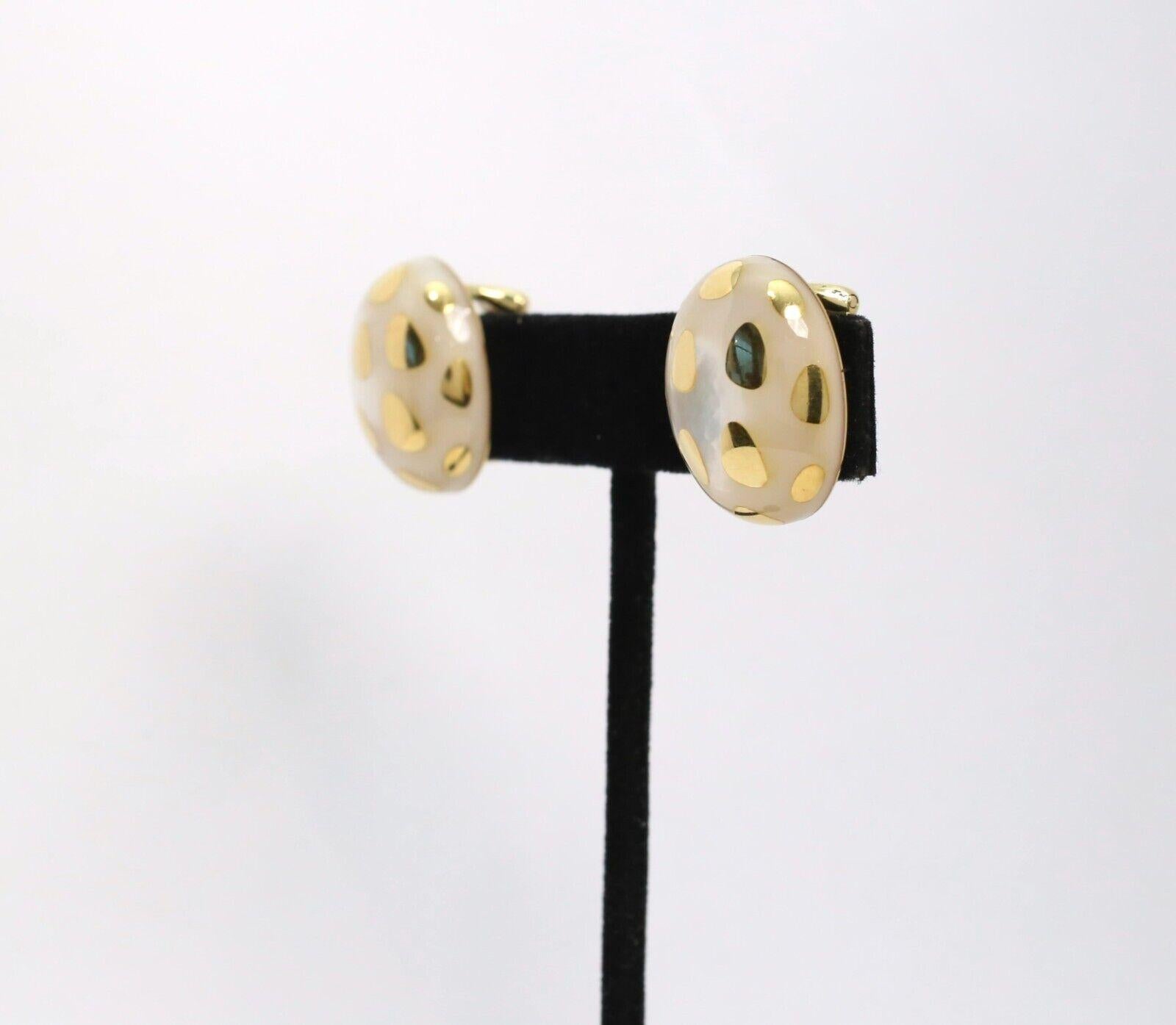 These stunning Tiffany & Co. earrings, designed by Angela Cummings, showcase an elegant fusion of 18K yellow gold and mother-of-pearl. The oval-shaped earrings feature a distinctive polka dot inlay pattern, where smooth gold accents contrast